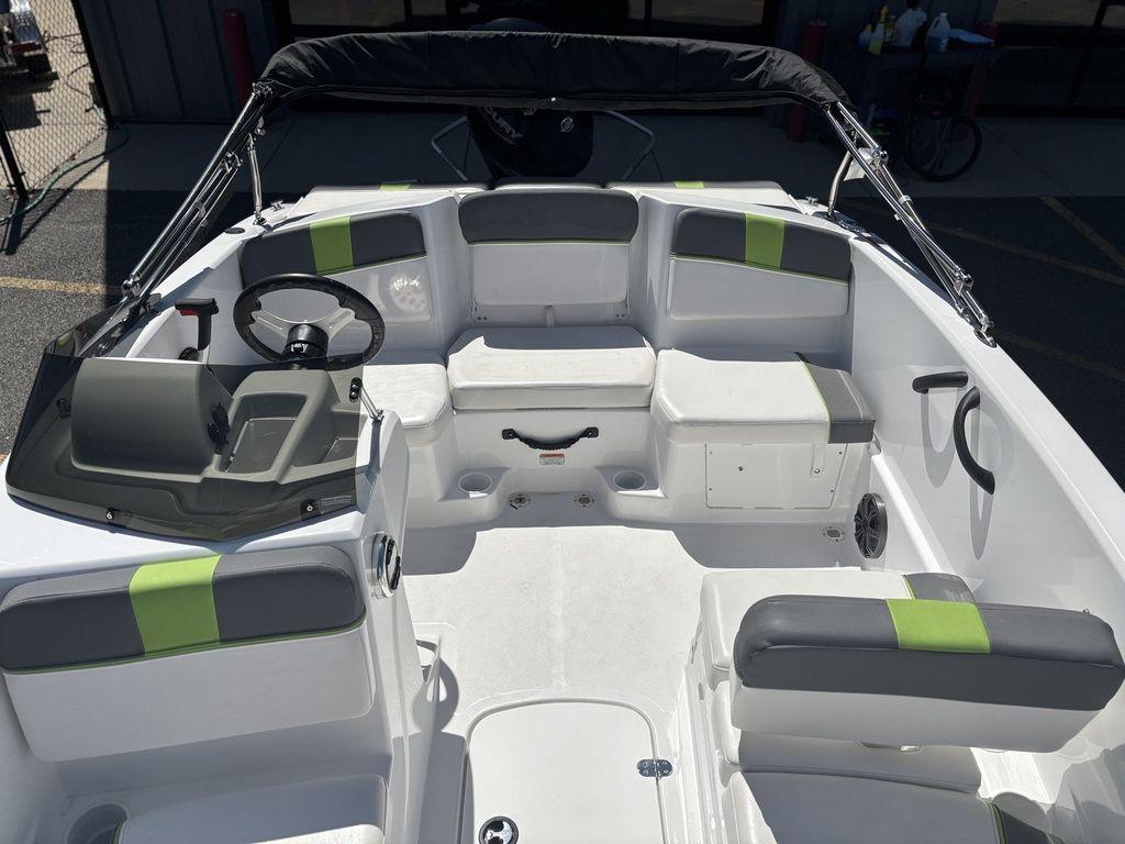 2024 Tahoe T16 boat interior with gray and green seating, steering wheel, and storage compartments.