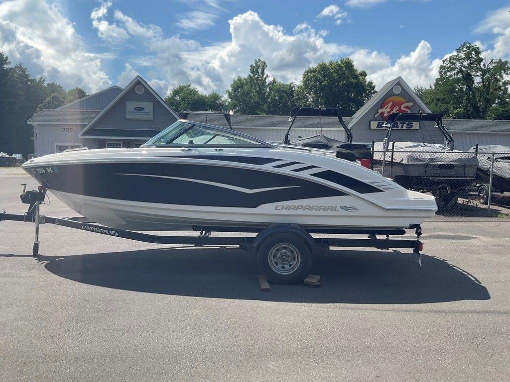 2018 Chaparral 203 VR boat on trailer, parked outside dealership under blue sky.