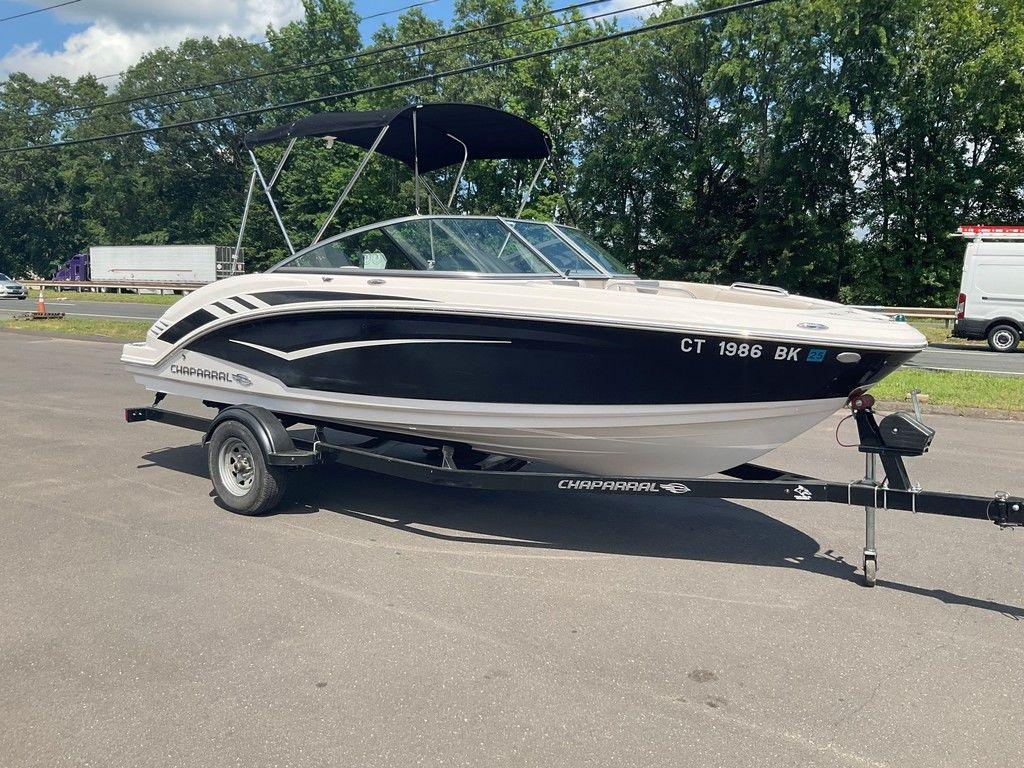 2018 Chaparral 203 VR boat on trailer, parked outdoors with trees in background.