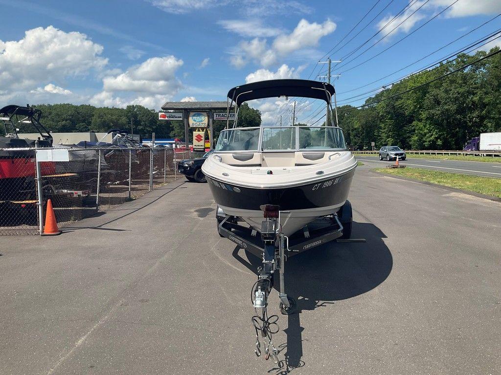 2018 Chaparral 203 VR boat on trailer, parked near dealership, under clear blue sky.