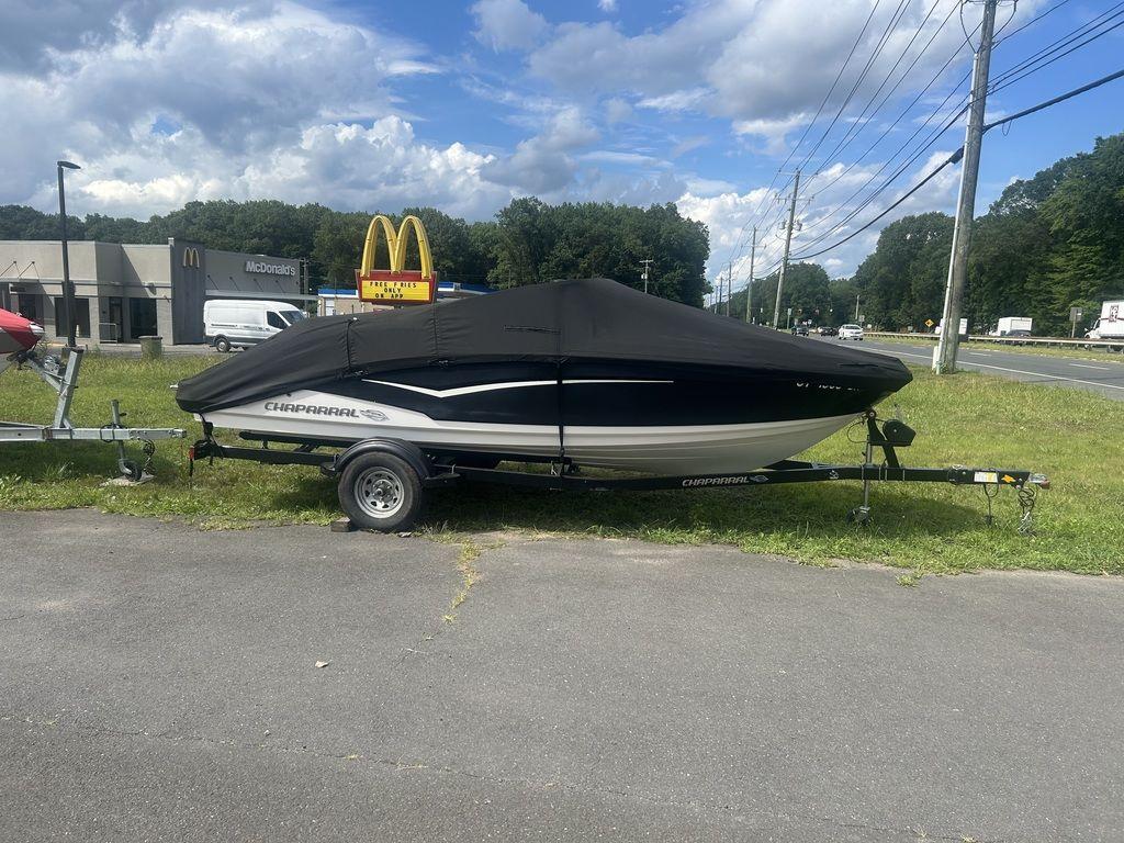 2018 Chaparral 203 VR boat on trailer, covered, near McDonald's, under cloudy sky.