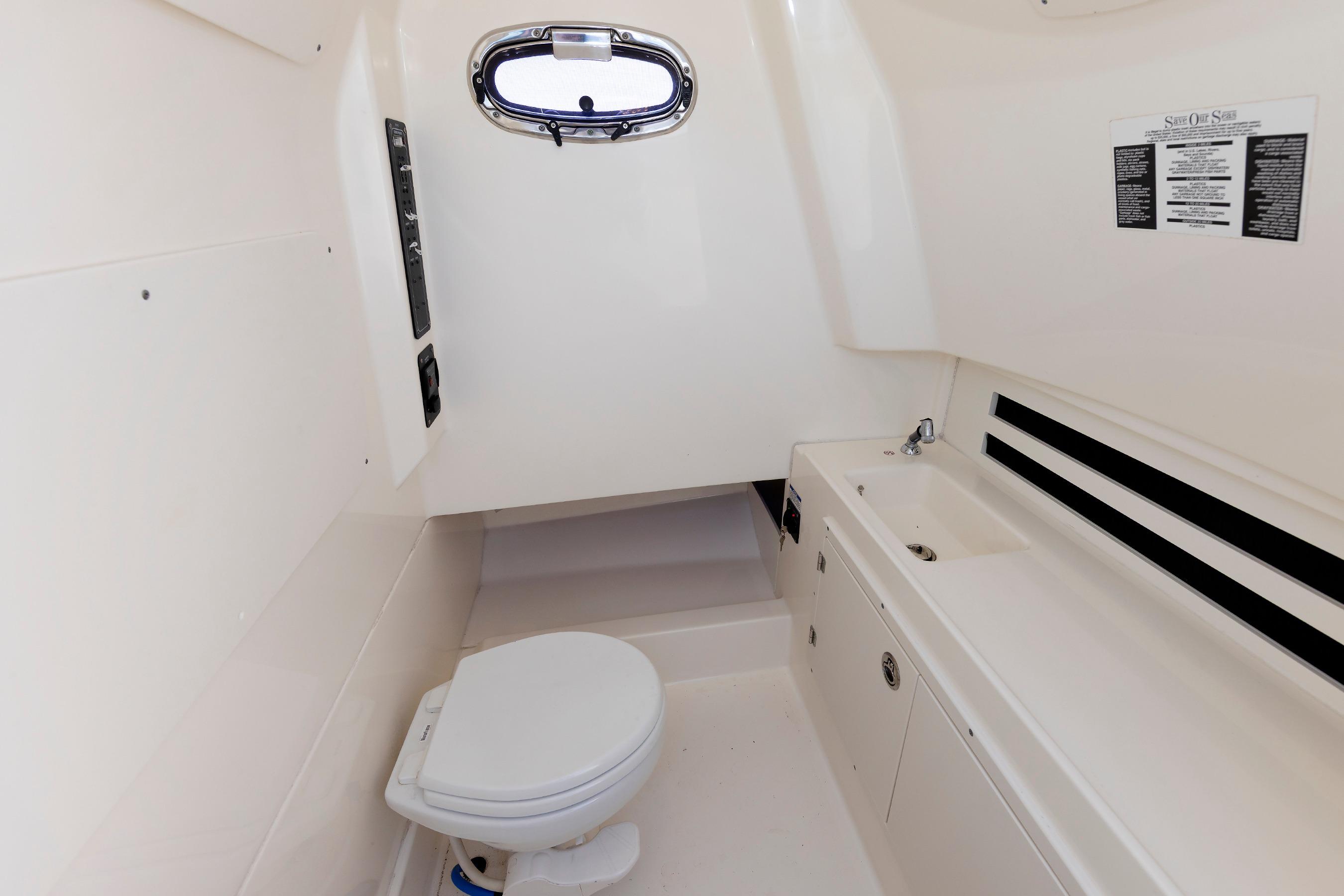 2016 Boston Whaler 330 Outrage boat interior with toilet and sink.