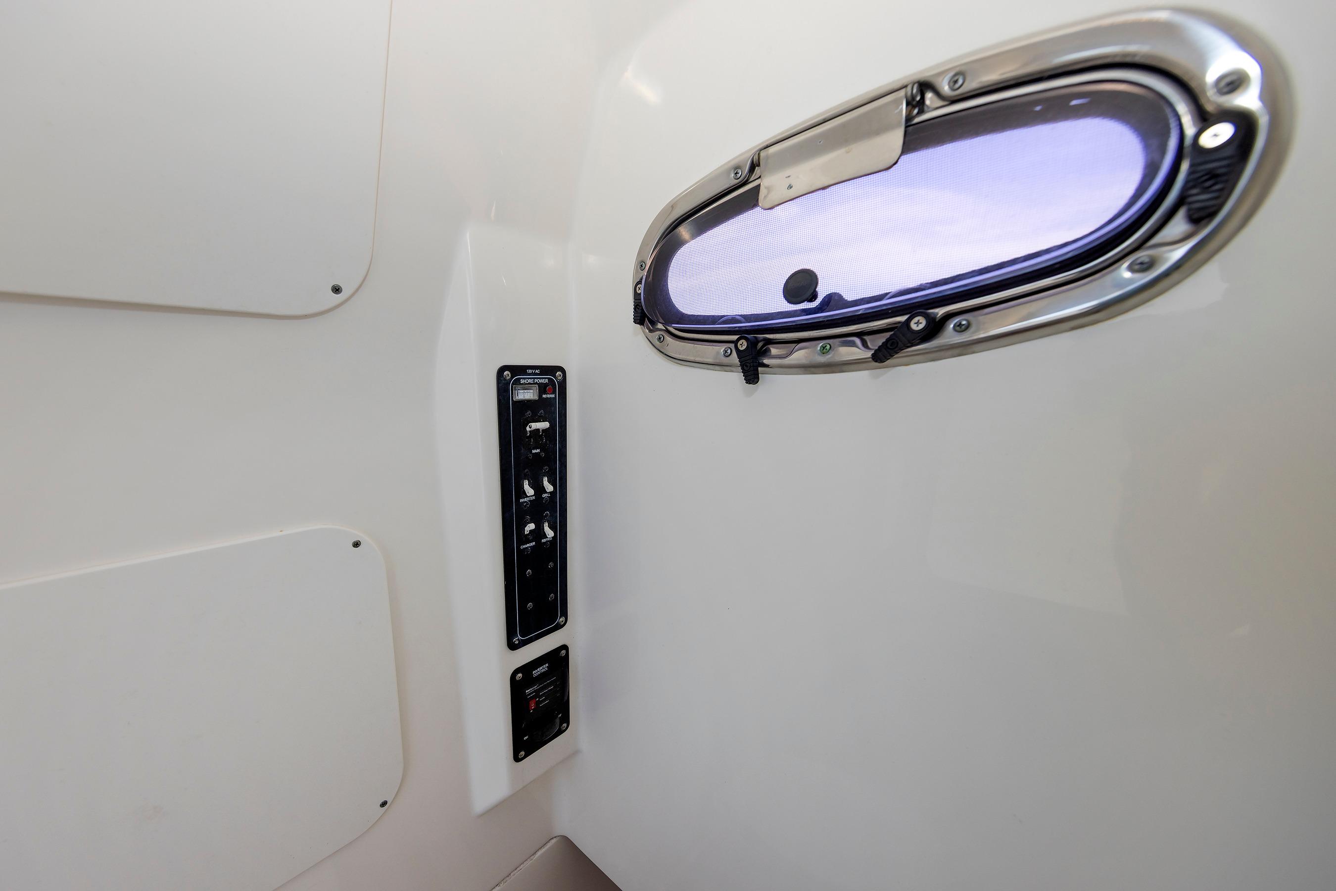 Interior view of 2016 Boston Whaler 330 Outrage with porthole and control panel.