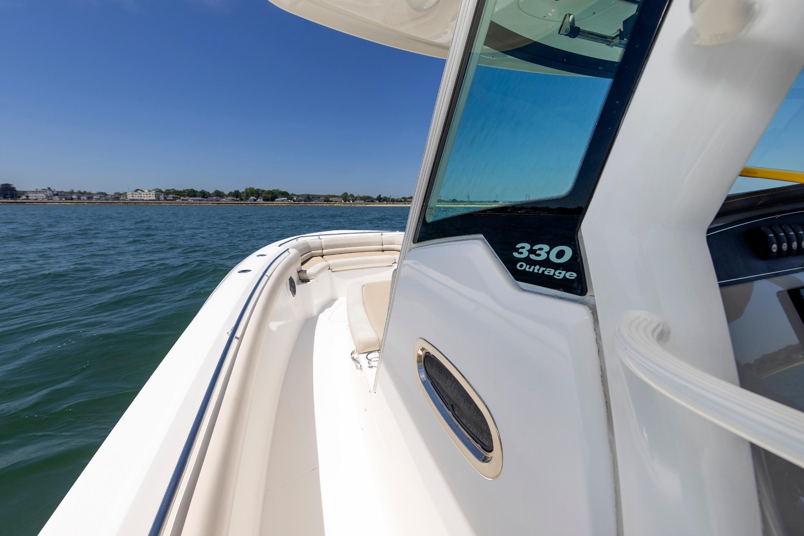 Boston Whaler 330 Outrage 2016 boat cruising on open water under clear blue sky.
