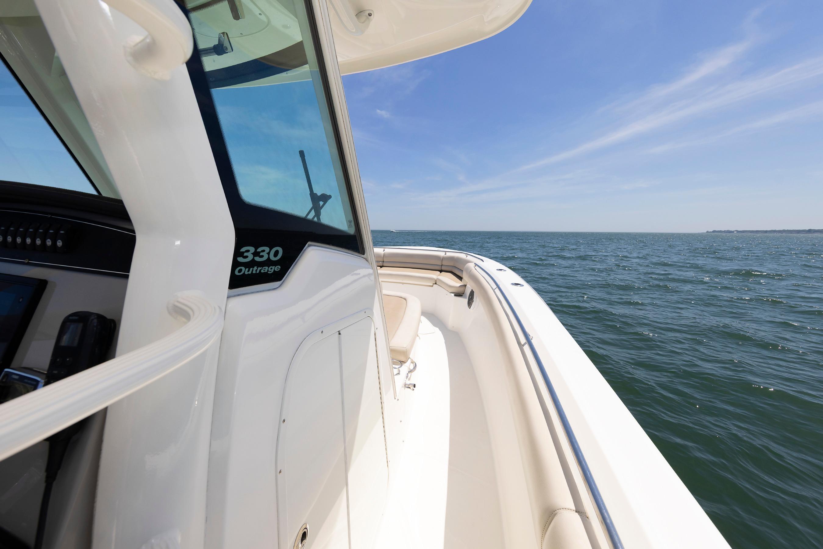 Boston Whaler 330 Outrage 2016 boat cruising on open water under clear blue sky.
