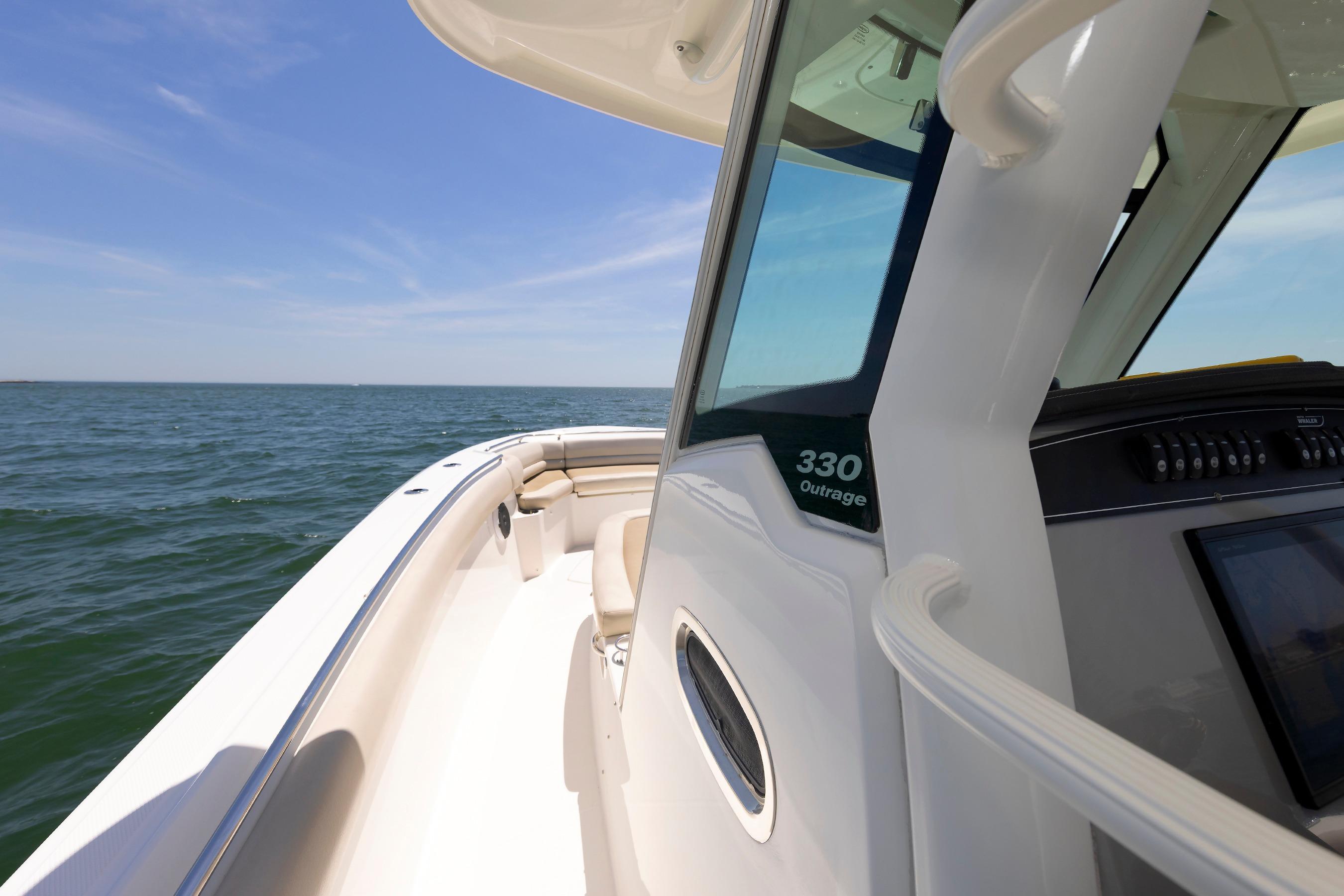 2016 Boston Whaler 330 Outrage boat cruising on open water under clear skies.