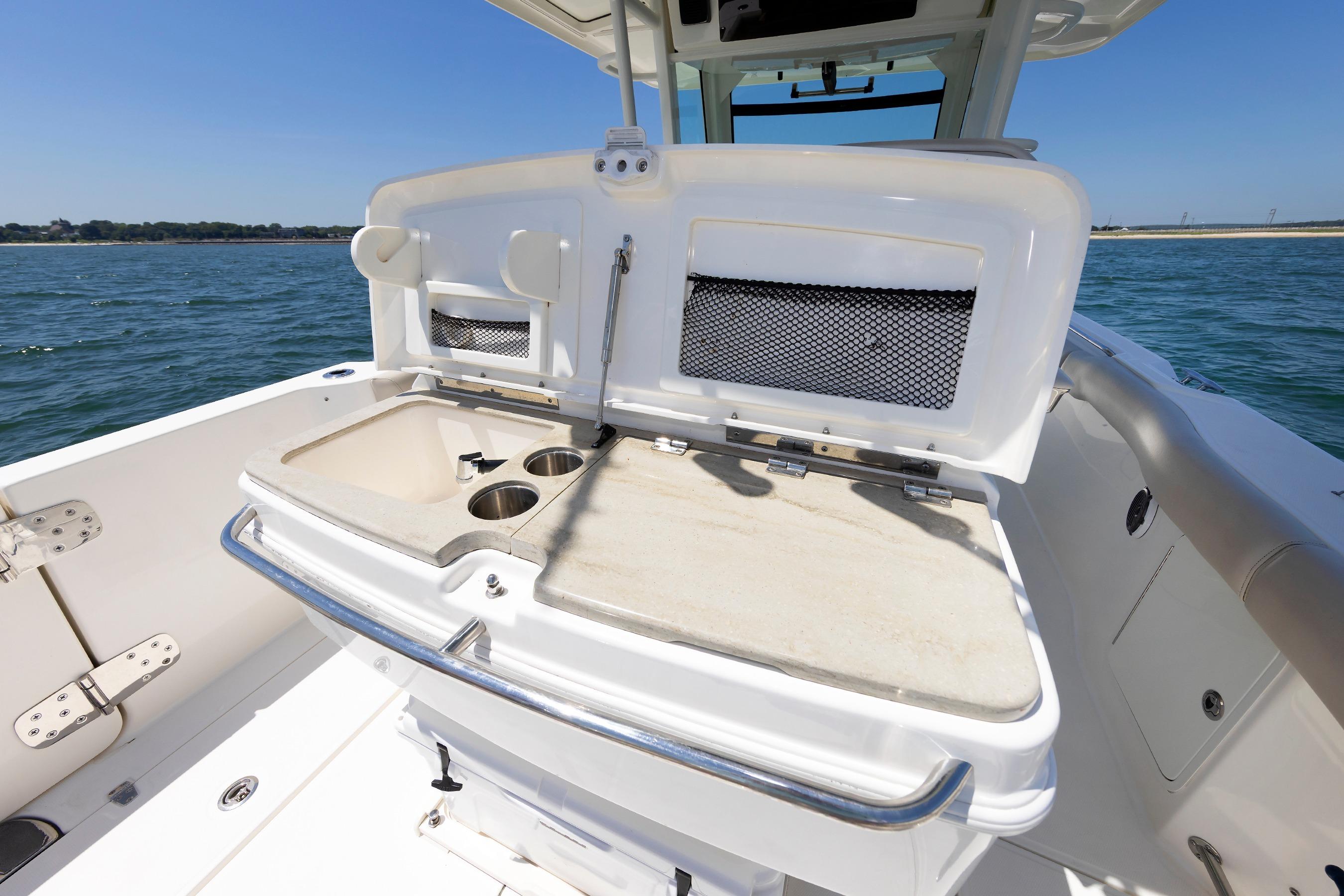 2016 Boston Whaler 330 Outrage boat interior with open storage and cup holders.