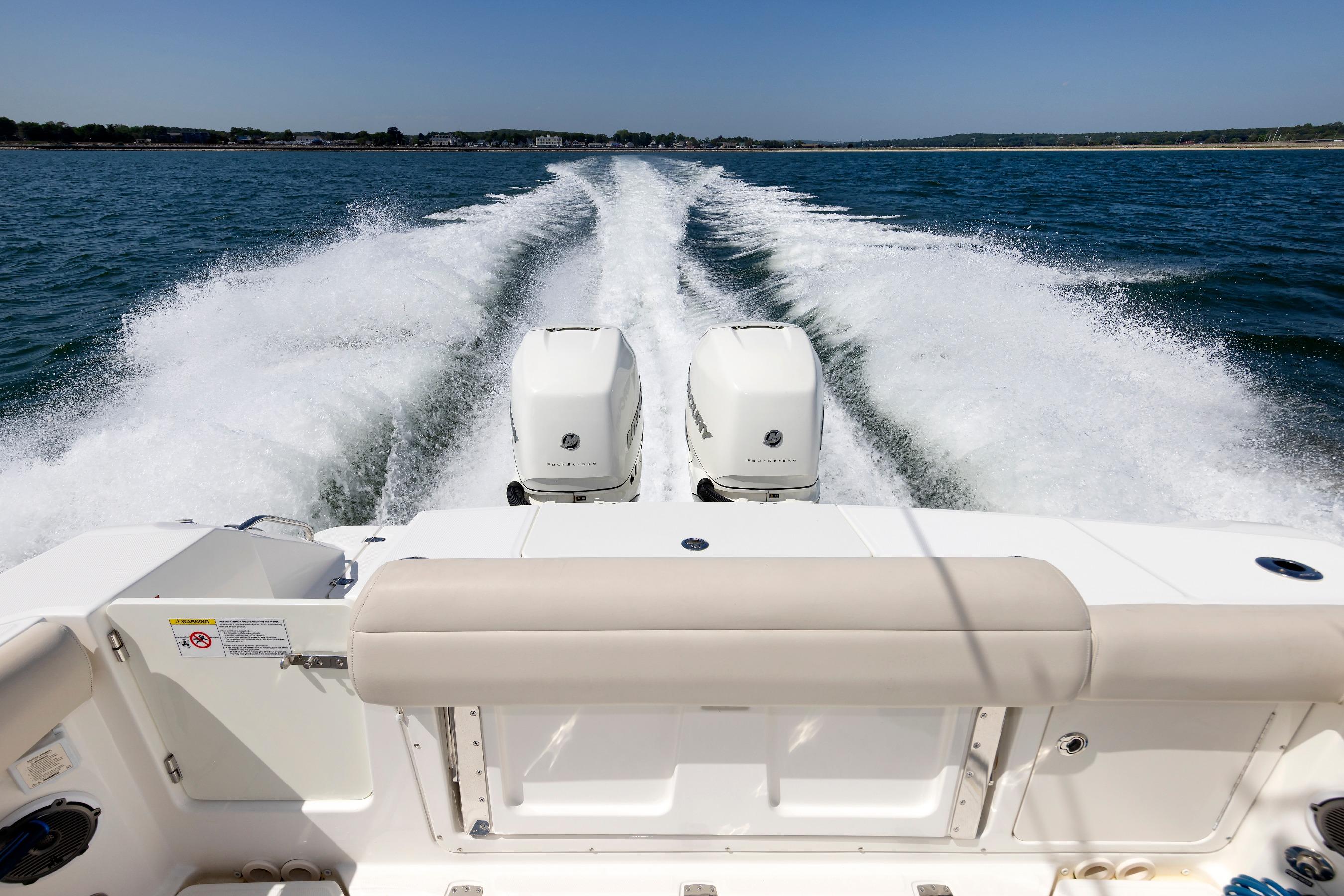 2016 Boston Whaler 330 Outrage cruising on open water, twin engines visible.