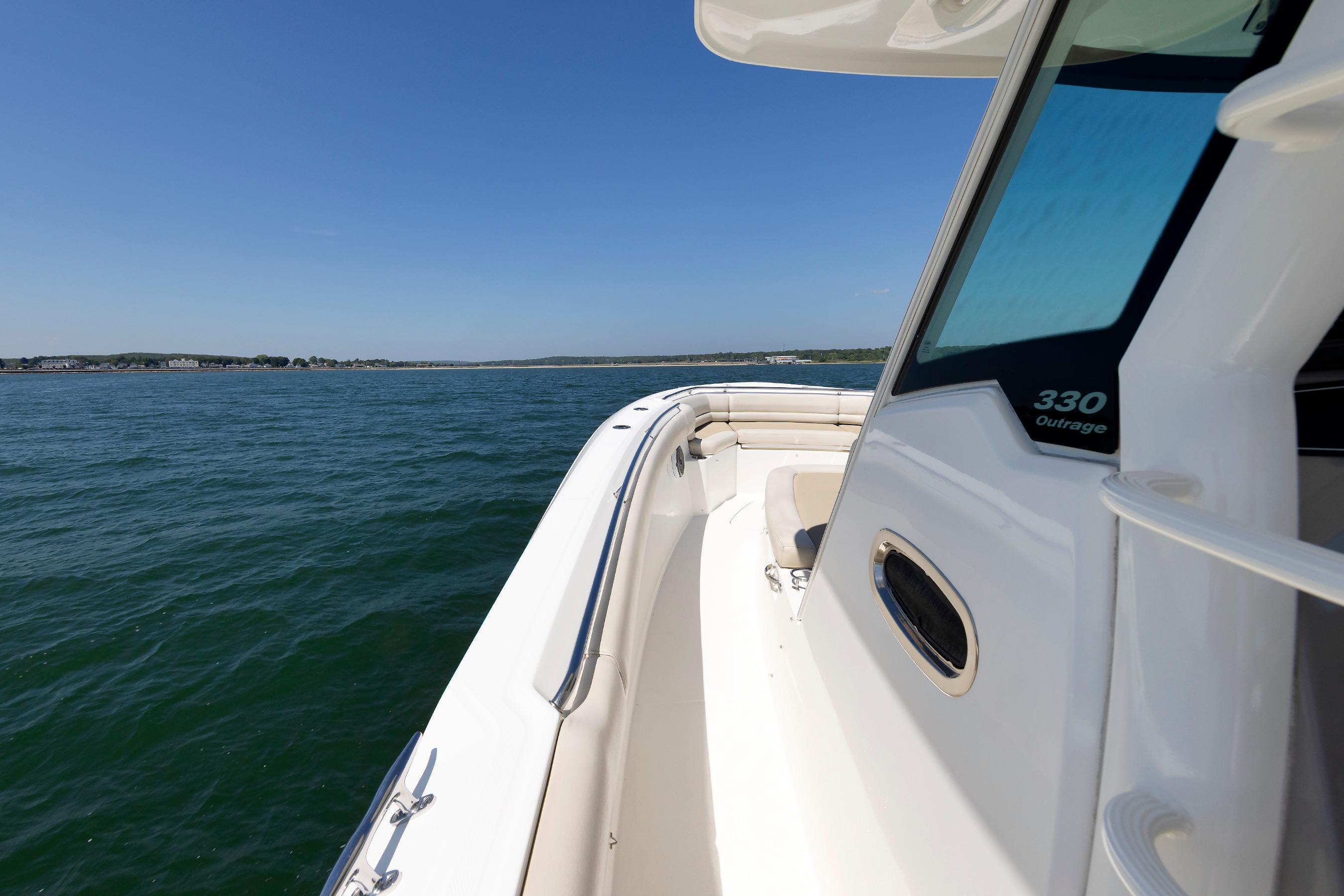 2016 Boston Whaler 330 Outrage boat cruising on open water under clear blue sky.