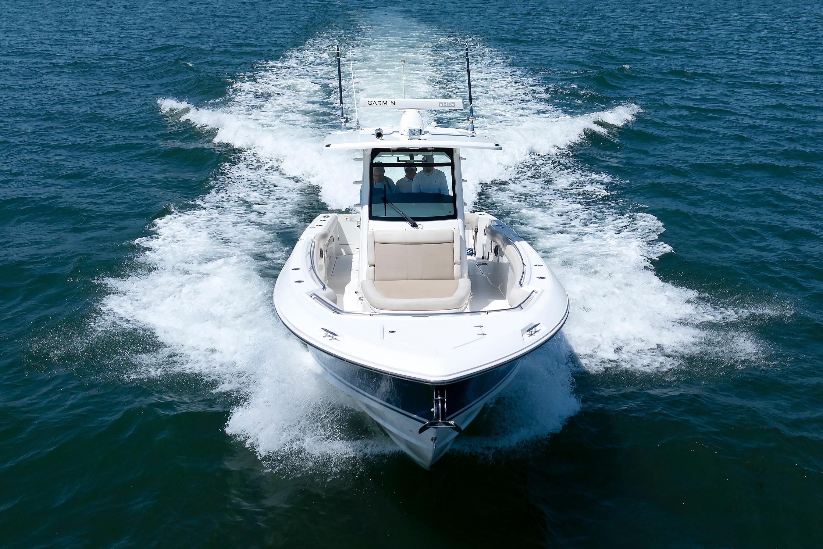 2016 Boston Whaler 330 Outrage cruising on open water, creating a dynamic wake.