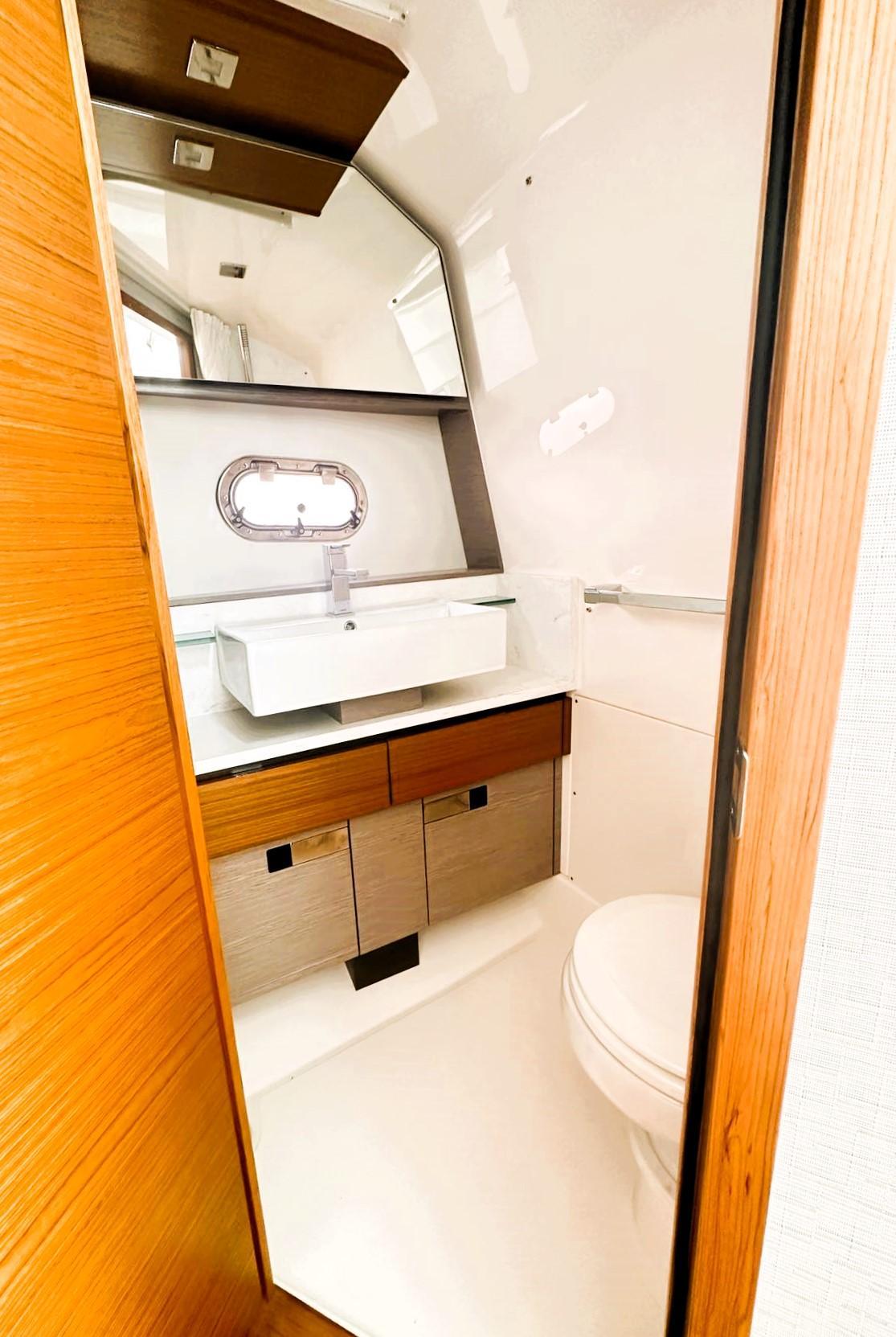 2024 Tiara Yachts 43 LS bathroom interior with modern sink and wooden cabinetry.