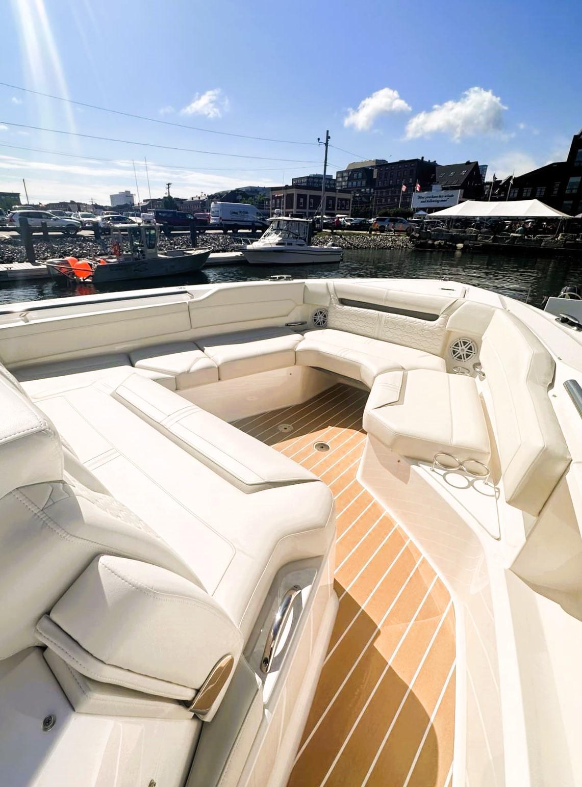 2024 Tiara Yachts 43 LS with luxurious seating, docked at a marina under a clear sky.
