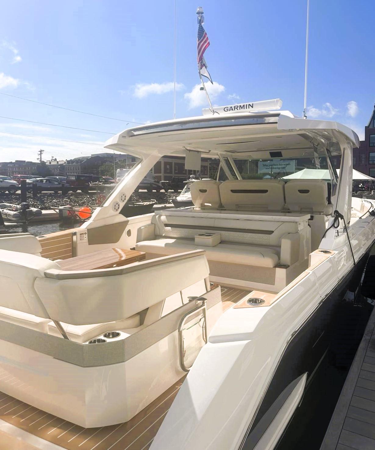 2024 Tiara Yachts 43 LS luxury boat with spacious seating and sleek design at a marina.