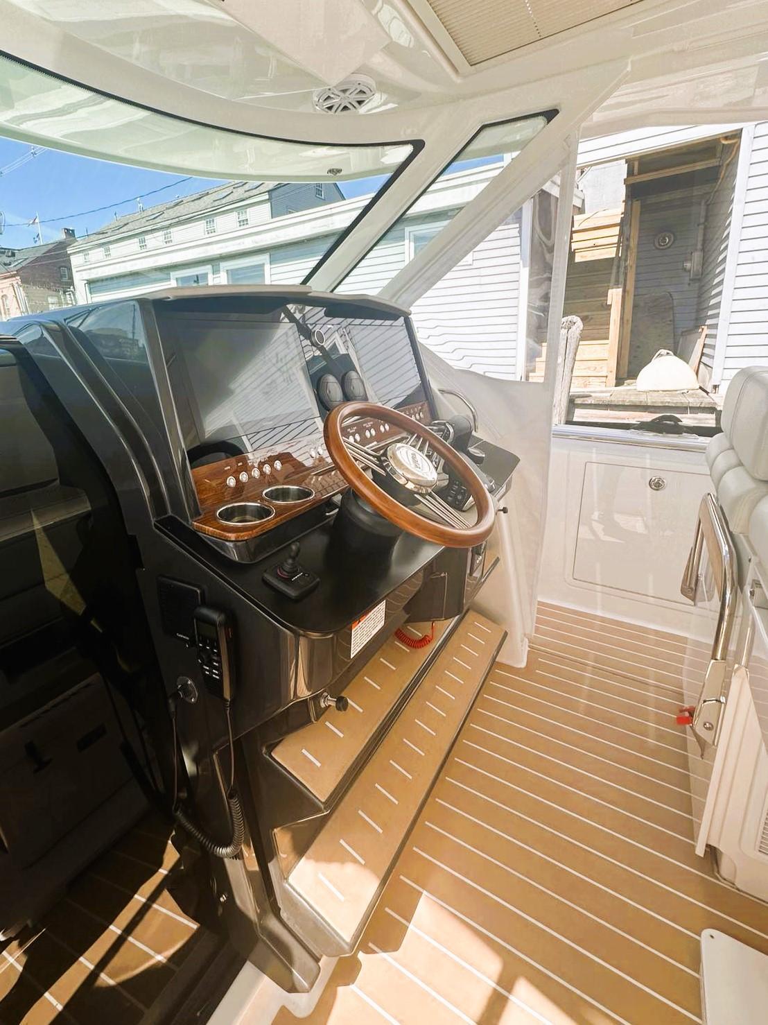 2024 Tiara Yachts 43 LS helm with wooden steering wheel and modern controls.