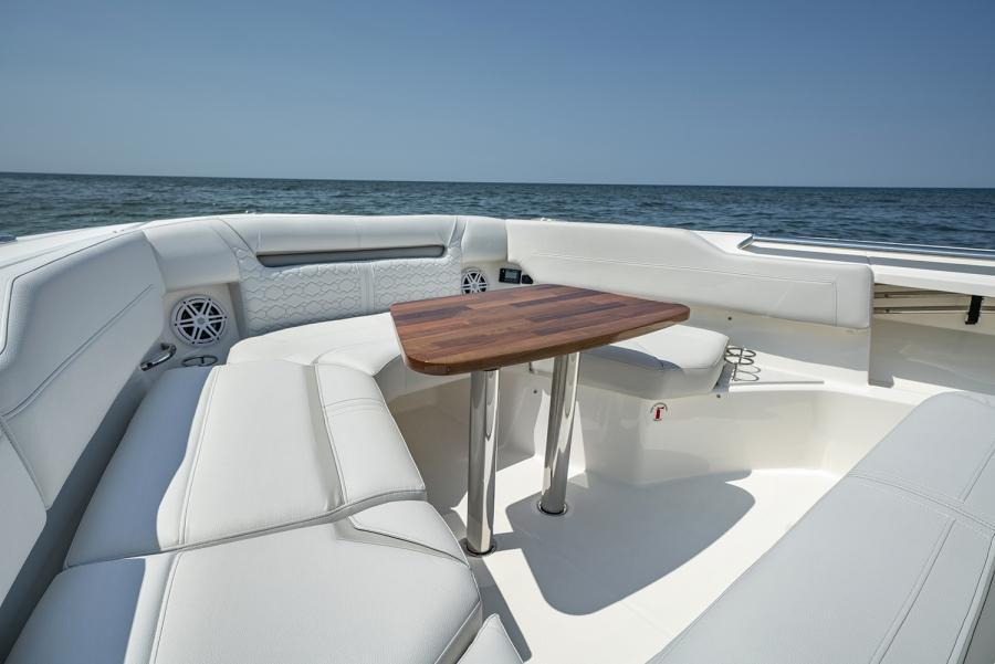 2024 Tiara Yachts 43 LS boat interior with white seating and wooden table, ocean view.
