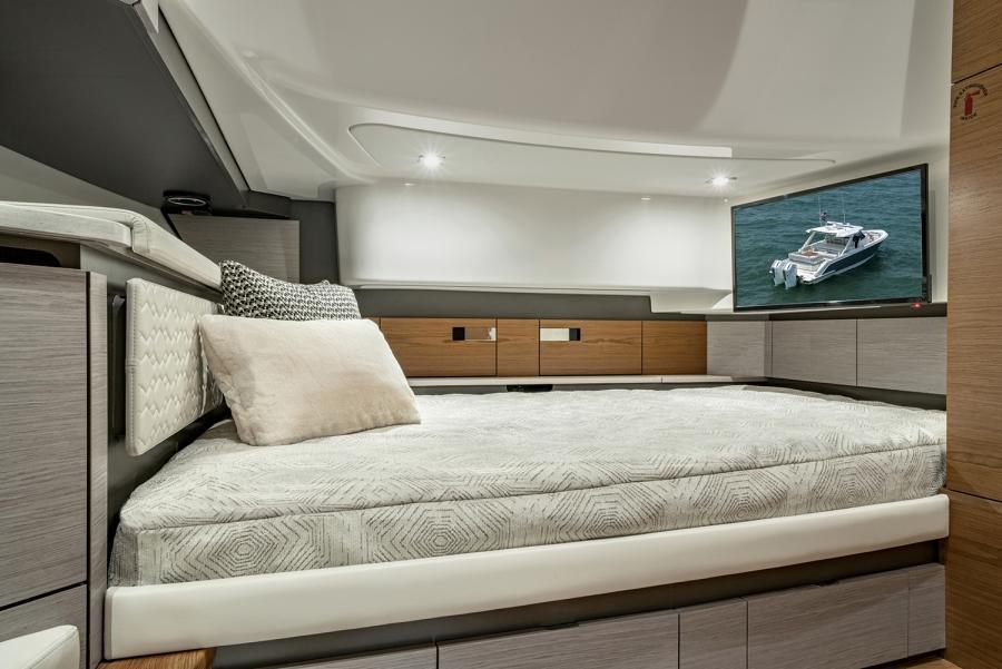 Luxurious interior of 2024 Tiara Yachts 43 LS with modern bedding and TV.