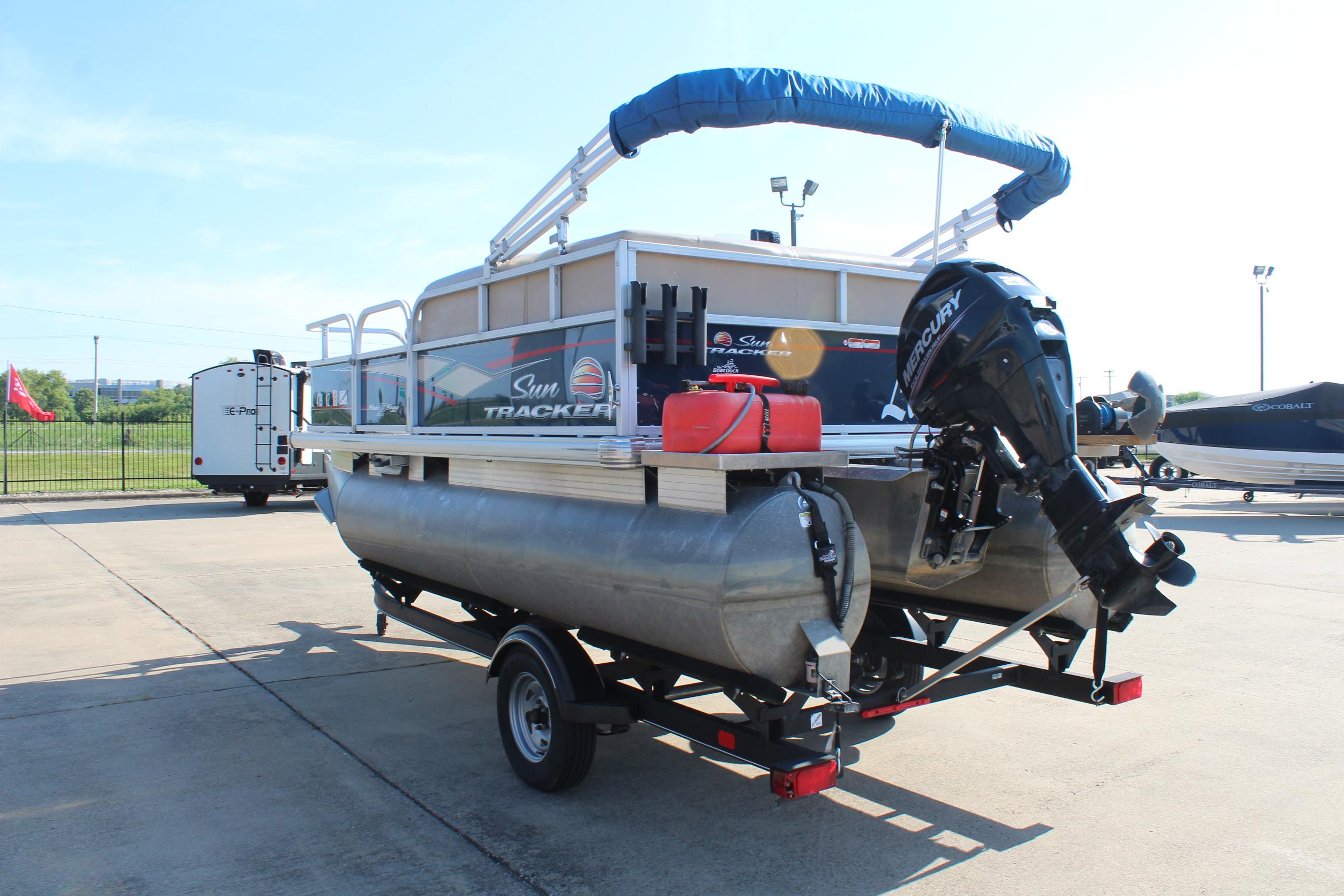 2019 Sun Tracker Bass Buggy 16 XL Select pontoon boat on trailer, outdoor setting.