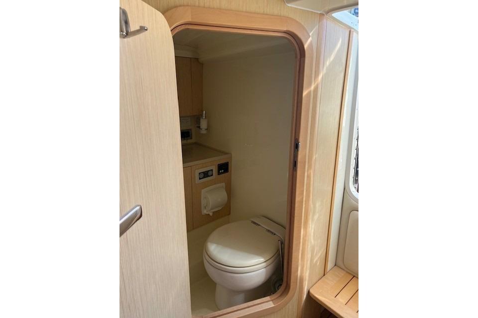 2017 Chris-Craft Corsair 32 boat interior bathroom with wooden finish and compact design.