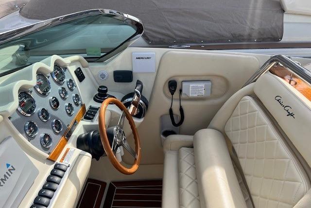 2017 Chris-Craft Corsair 32 cockpit with leather seats and wooden steering wheel.