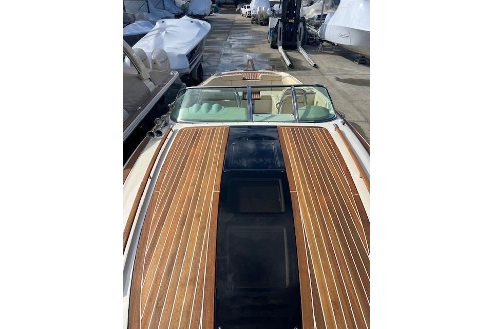 2017 Chris-Craft Corsair 32 with sleek wooden deck, docked among other boats.