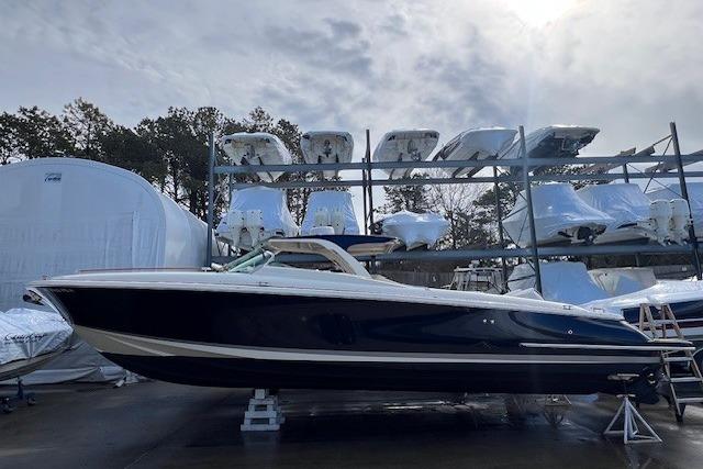 2017 Chris-Craft Corsair 32 boat in storage, surrounded by other vessels.