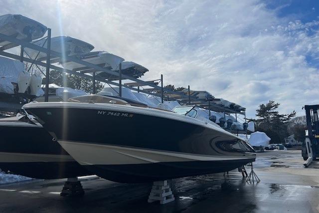 2017 Chris-Craft Corsair 32 boat in storage, under a partly cloudy sky.