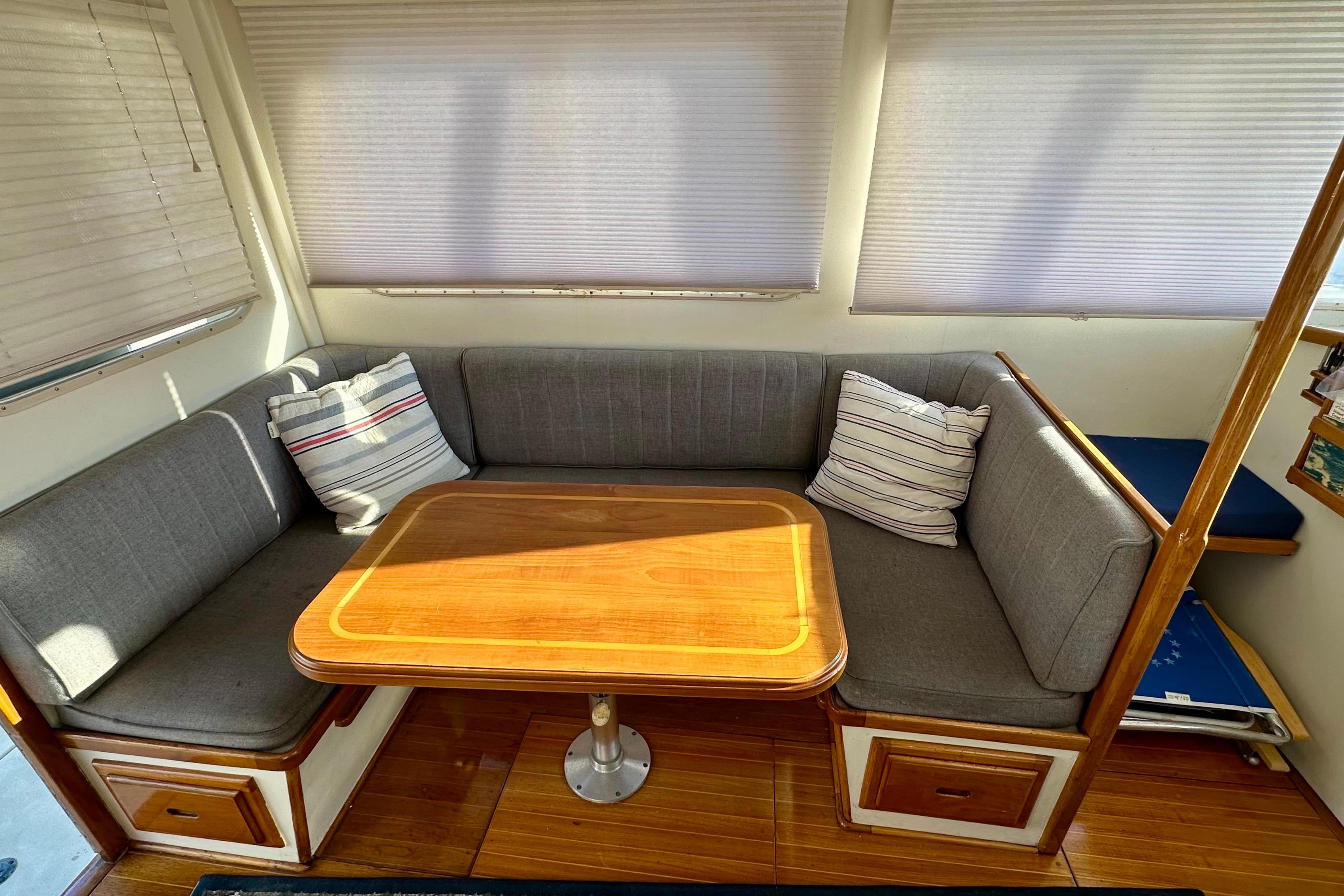 1982 Jarvis Newman Flybridge Cruiser interior with cozy seating and wooden table.
