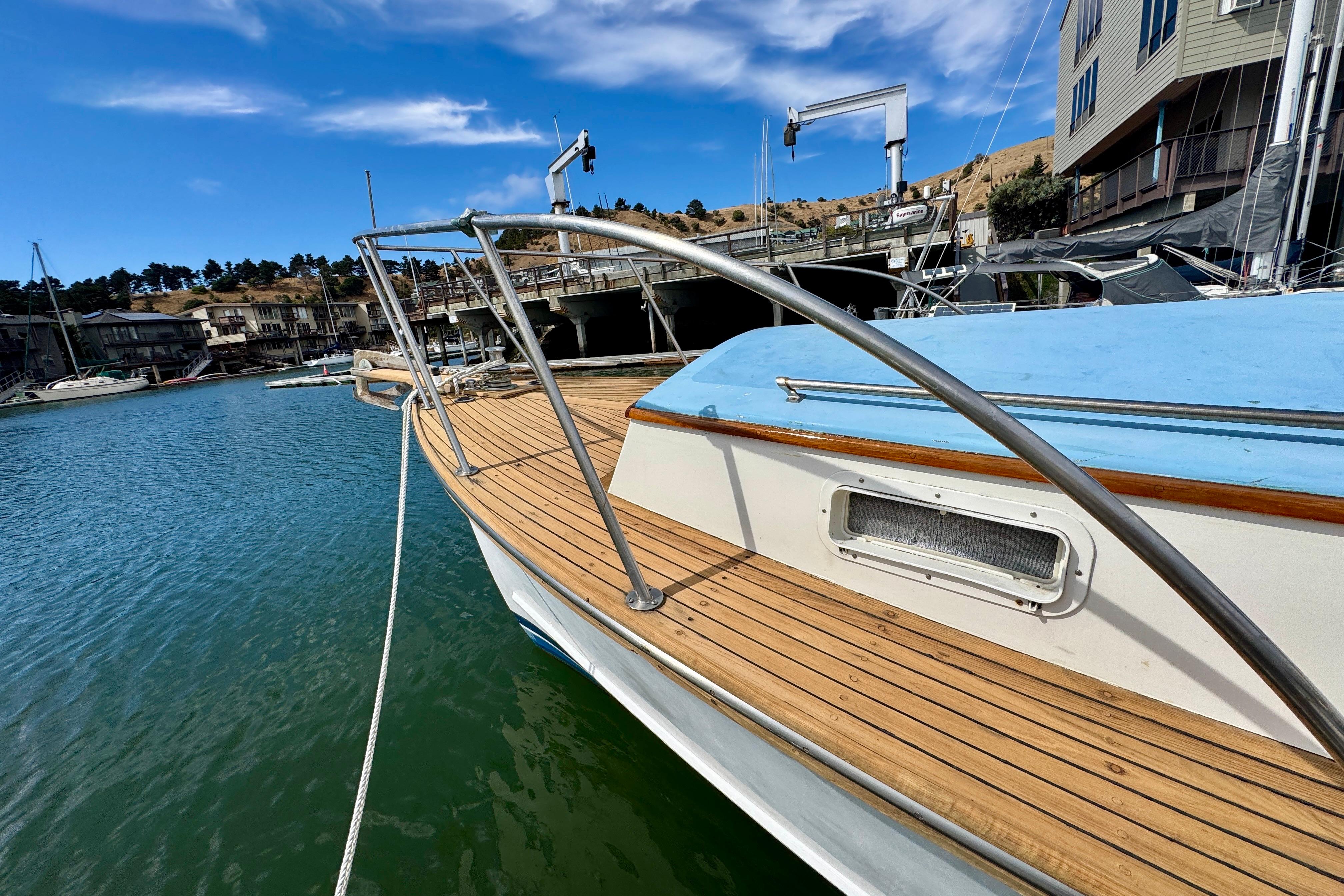 1982 Jarvis Newman Flybridge Cruiser docked at marina, featuring wooden deck and blue cover.
