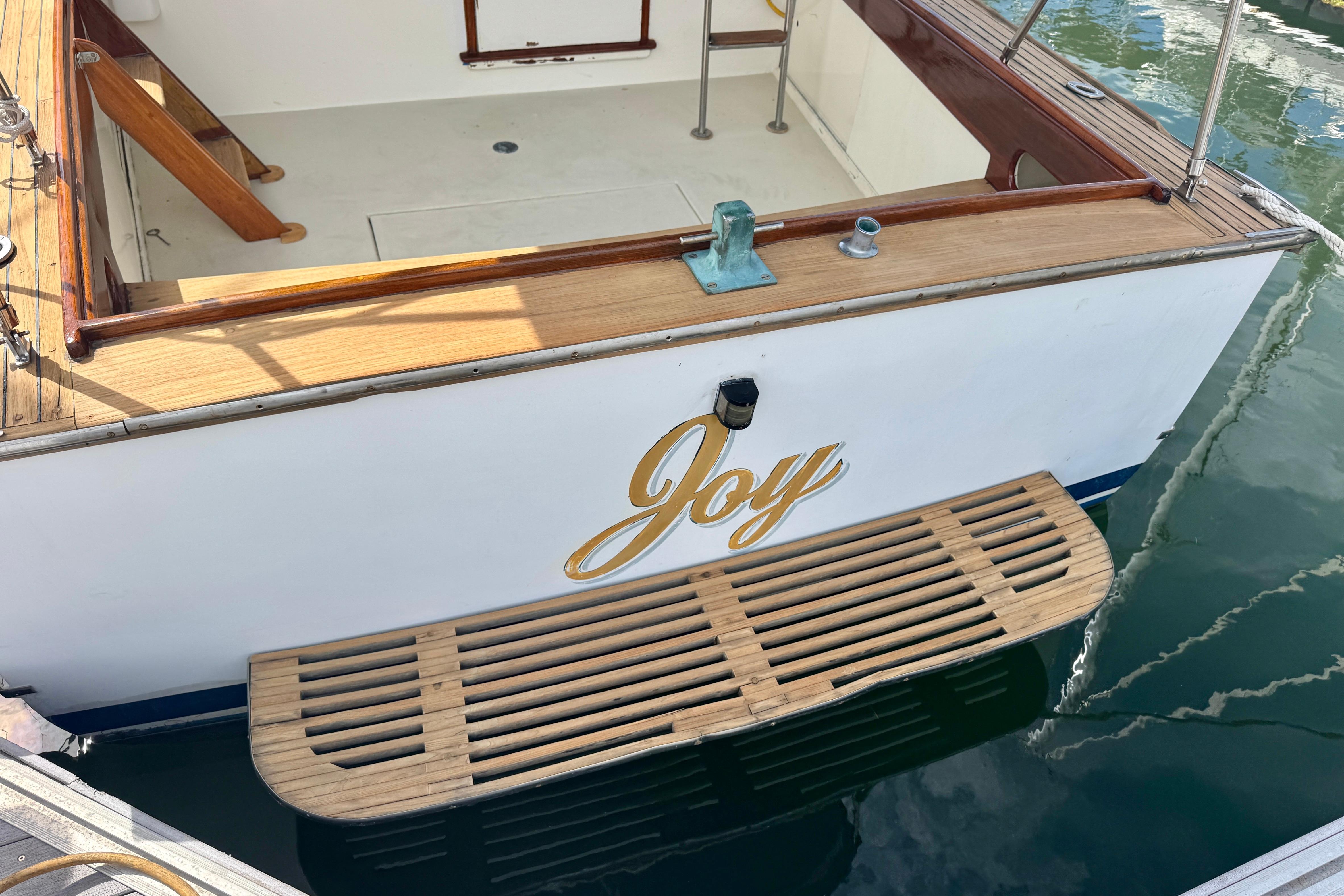 1982 Jarvis Newman Flybridge Cruiser named "Joy" with wooden deck and swim platform.