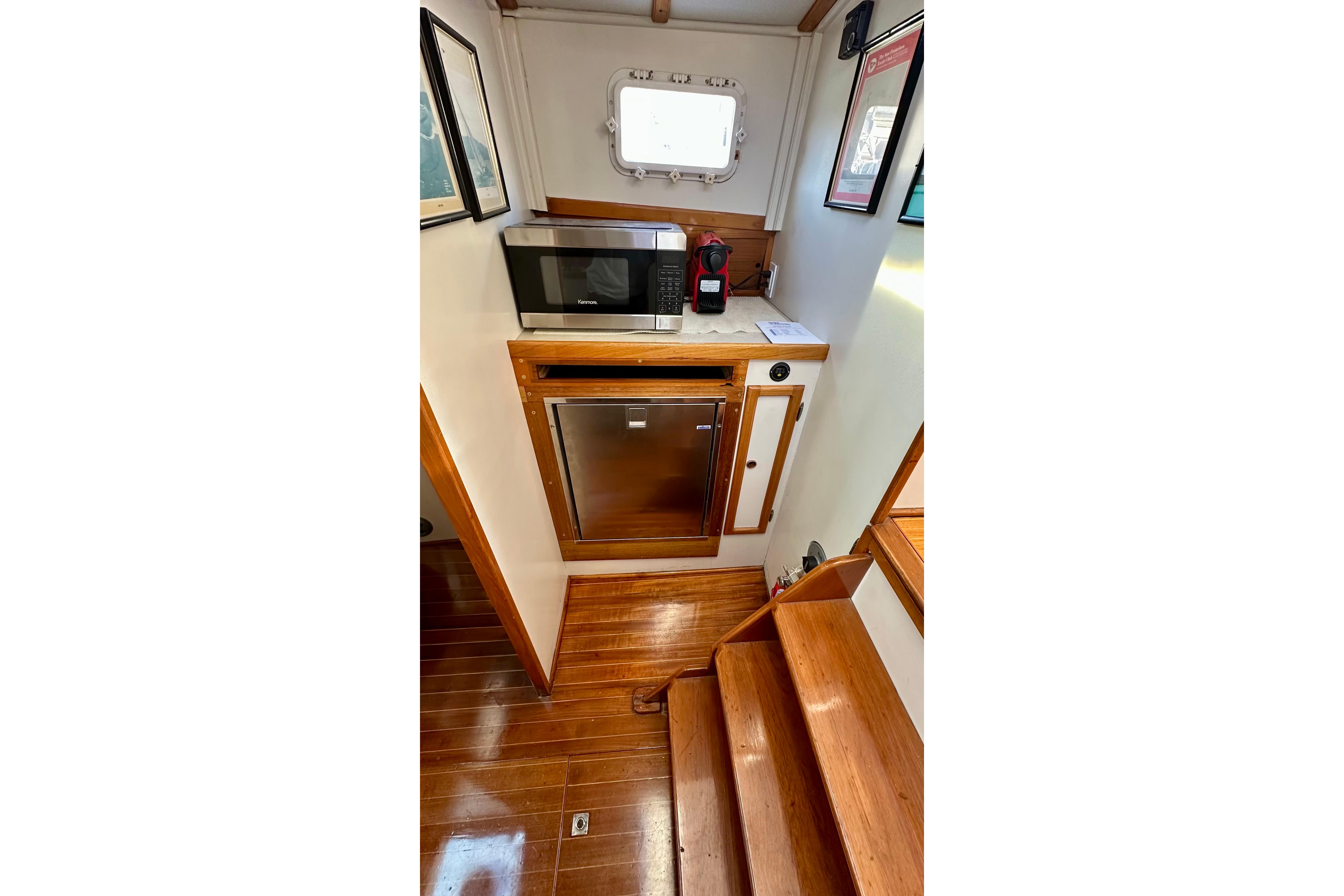 1982 Jarvis Newman Flybridge Cruiser interior with microwave, fridge, and wooden flooring.