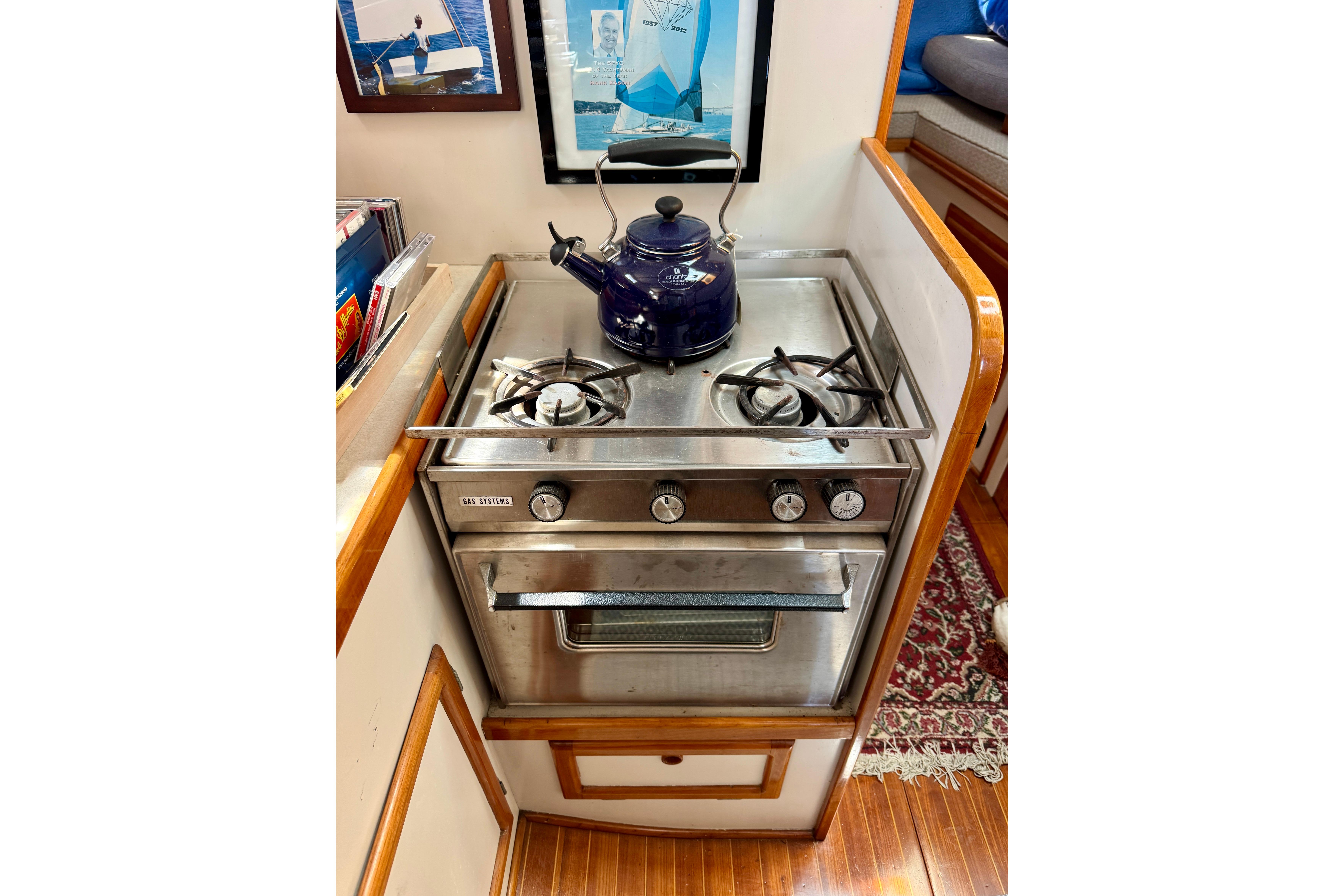 1982 Jarvis Newman Flybridge Cruiser kitchen with stove, kettle, and nautical decor.