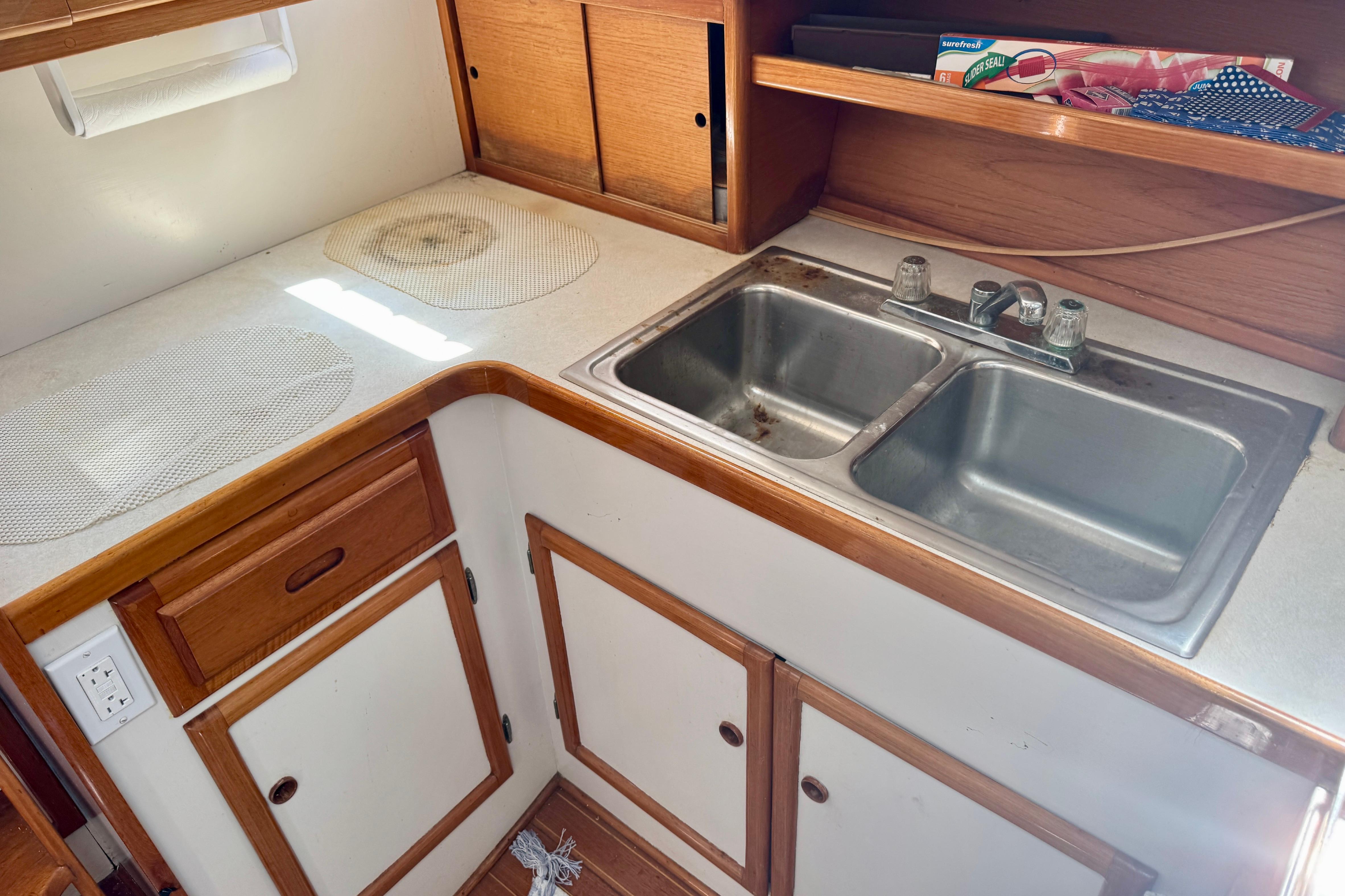 1982 Jarvis Newman Flybridge Cruiser kitchen with double sink and wooden cabinetry.