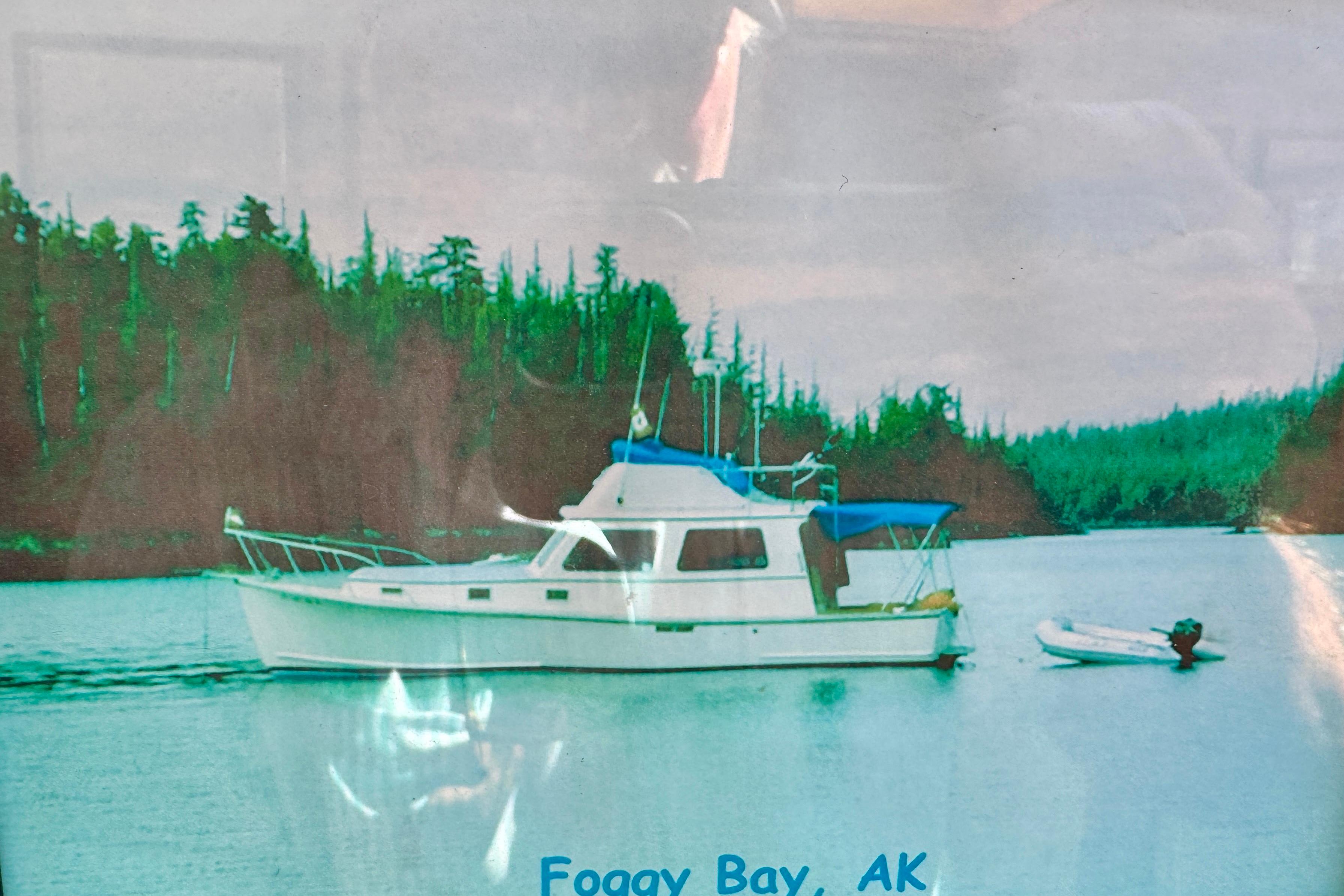 1982 Jarvis Newman Flybridge Cruiser in Foggy Bay, Alaska, surrounded by lush forest.