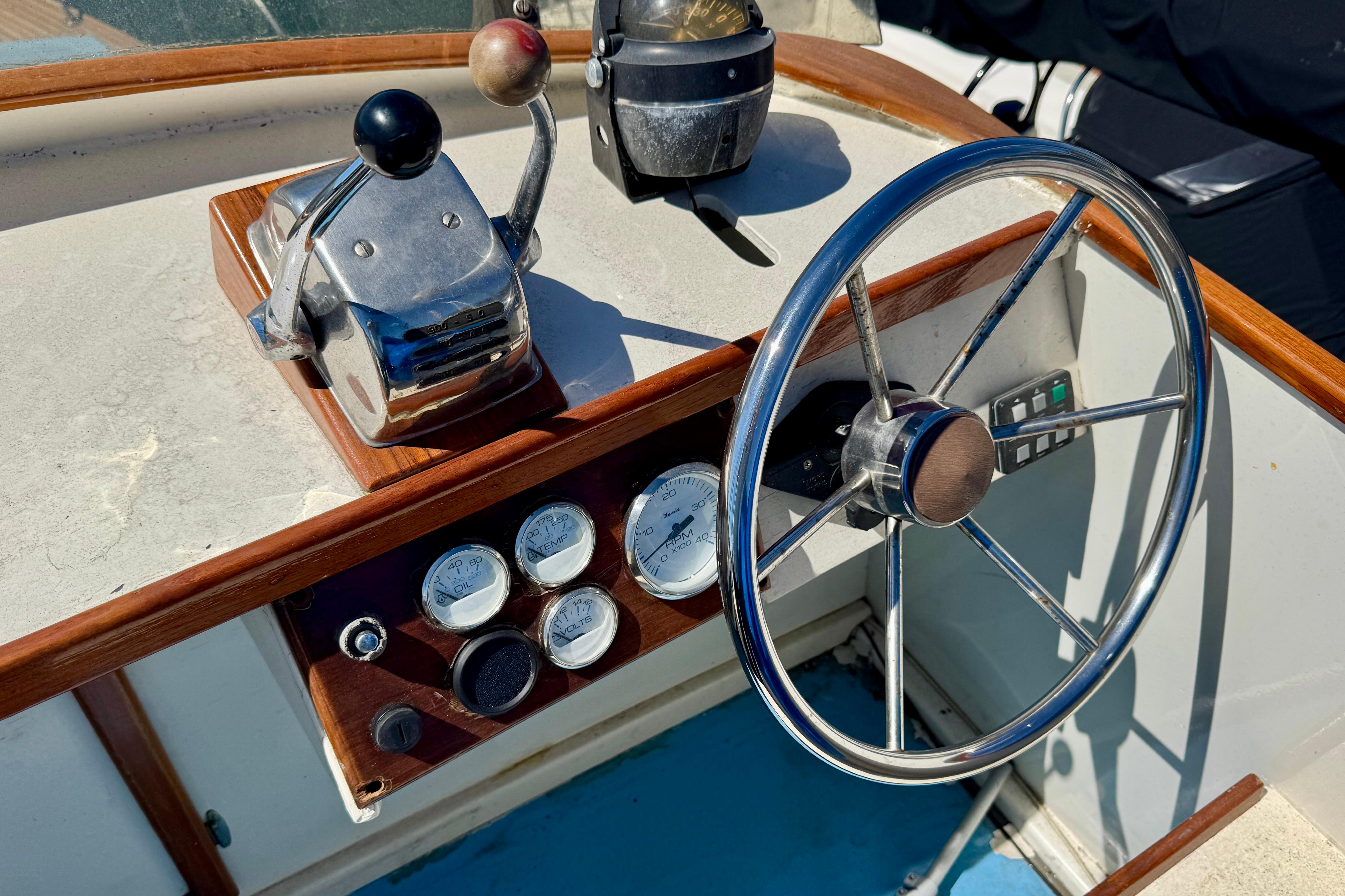 1982 Jarvis Newman Flybridge Cruiser helm with steering wheel and control panel.