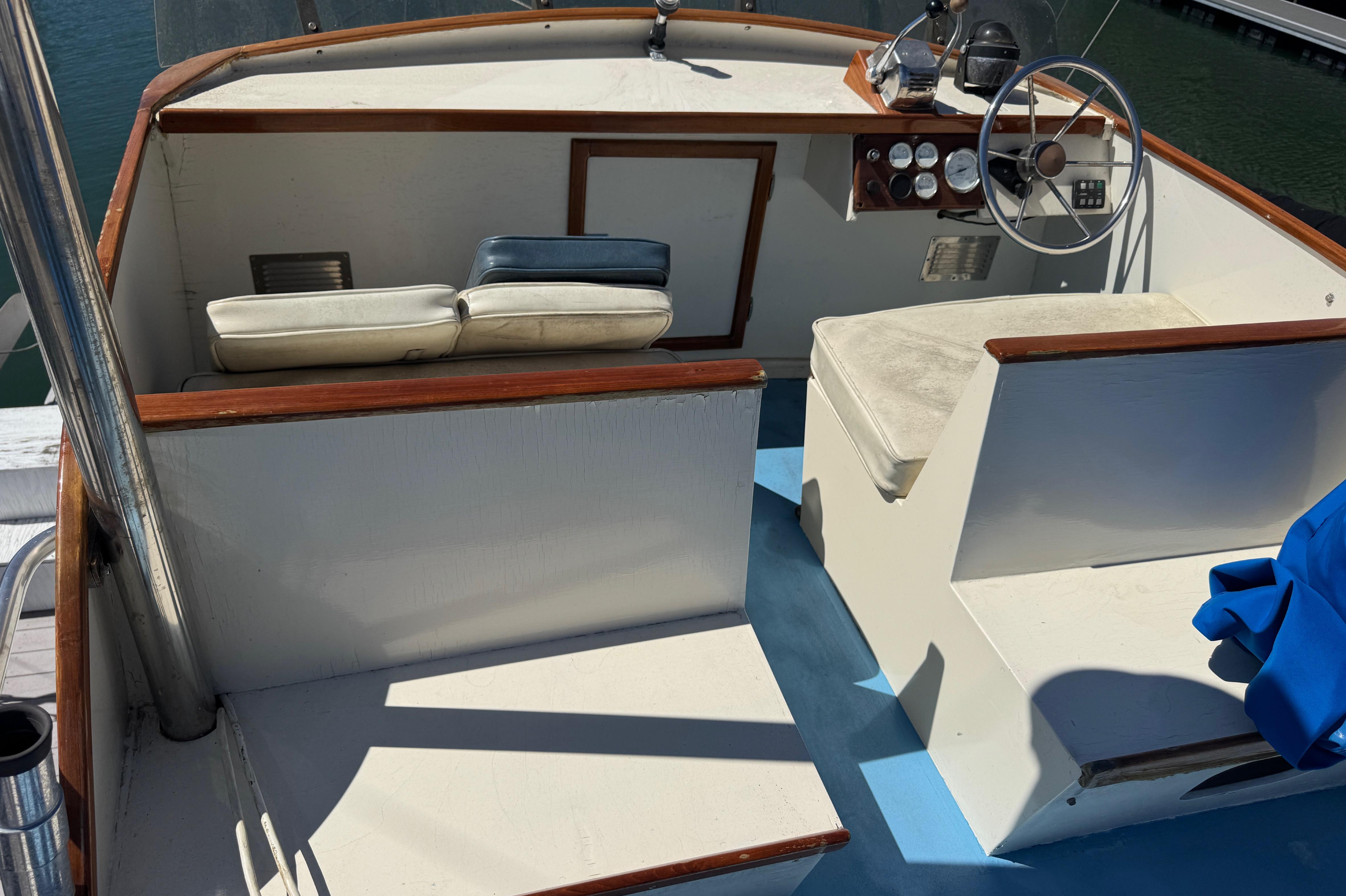 1982 Jarvis Newman Flybridge Cruiser helm with seating, steering wheel, and control panel.