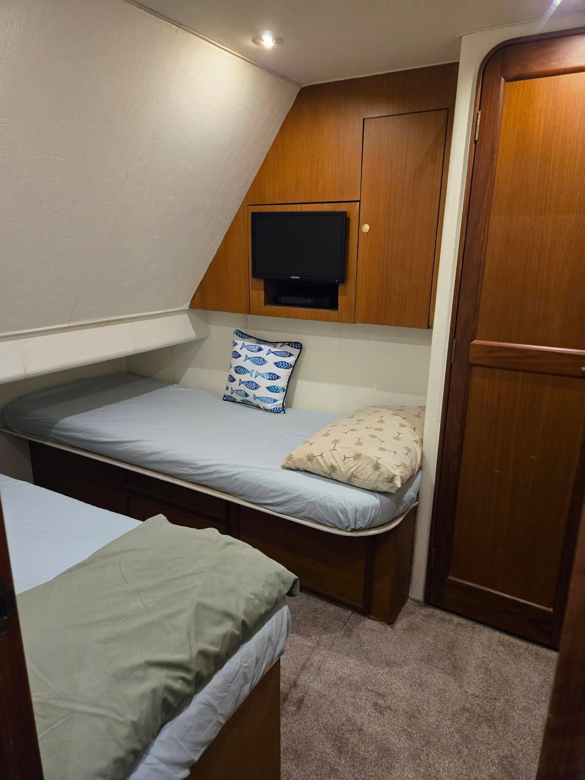 Ocean Yachts-48 Super Sport 1999 -VA-US-1999 Ocean Yachts 48 Super Sport cabin with twin beds and wall-mounted TV.-9409411 | Thumbnail