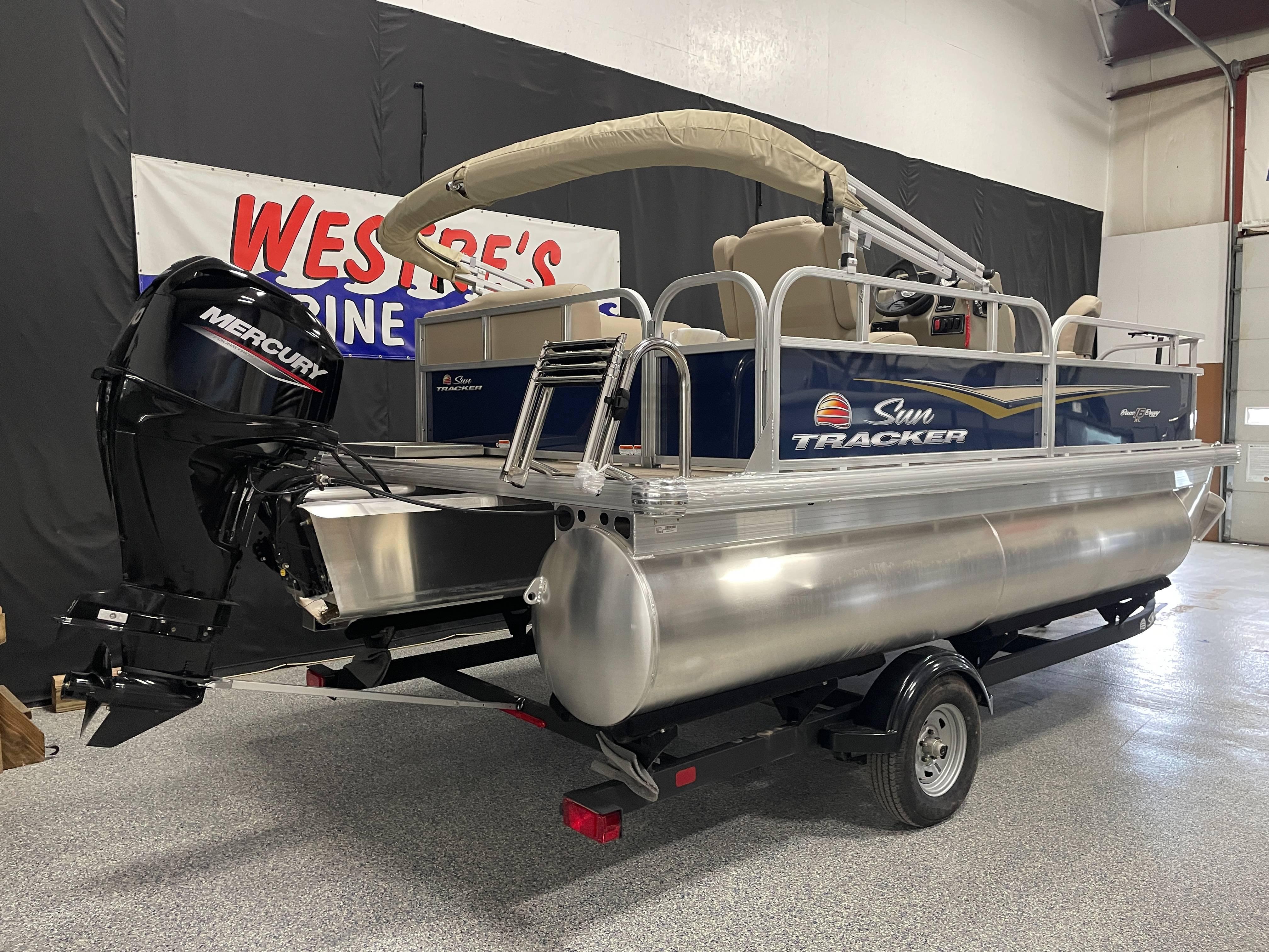 2025 Sun Tracker Bass Buggy 16 XL Select pontoon boat with Mercury engine in showroom.