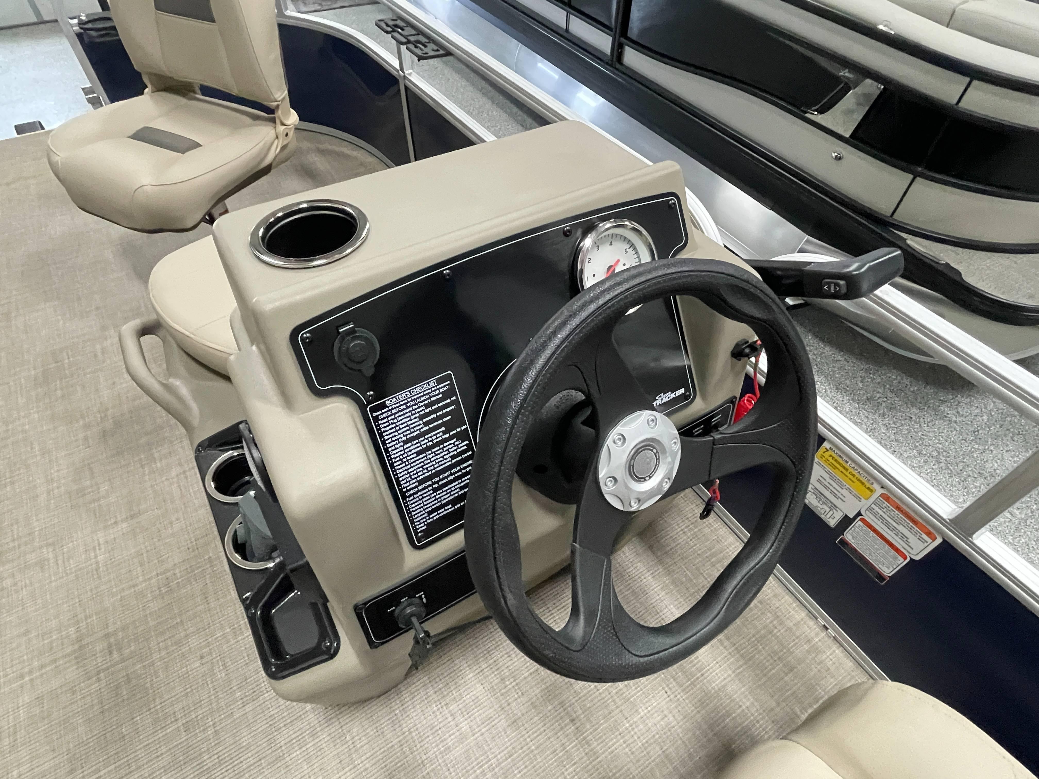2025 Sun Tracker Bass Buggy 16 XL Select boat steering console with cup holders and seating.