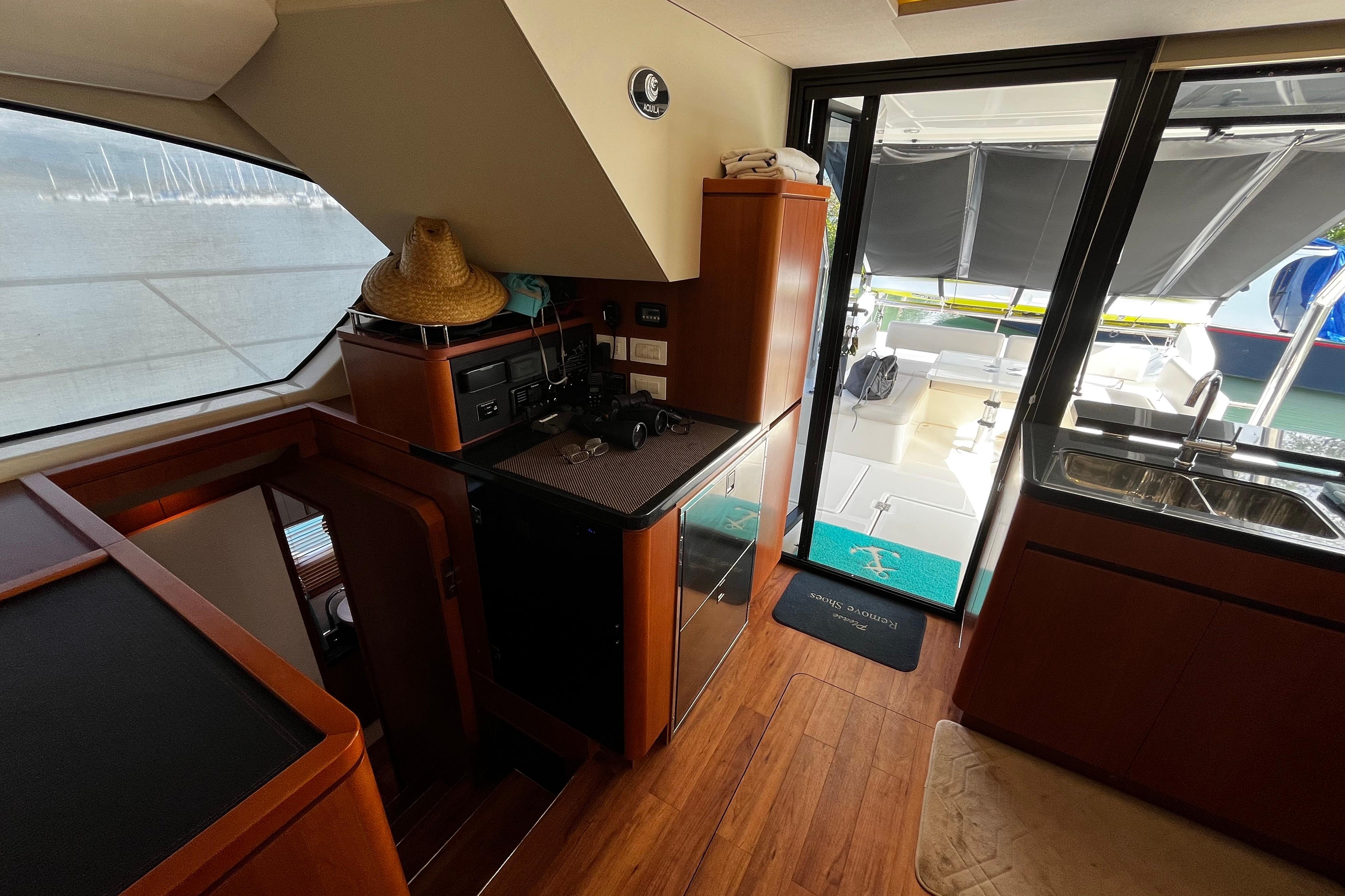 Interior of 2016 Aquila 44 yacht with wooden flooring and outdoor view.