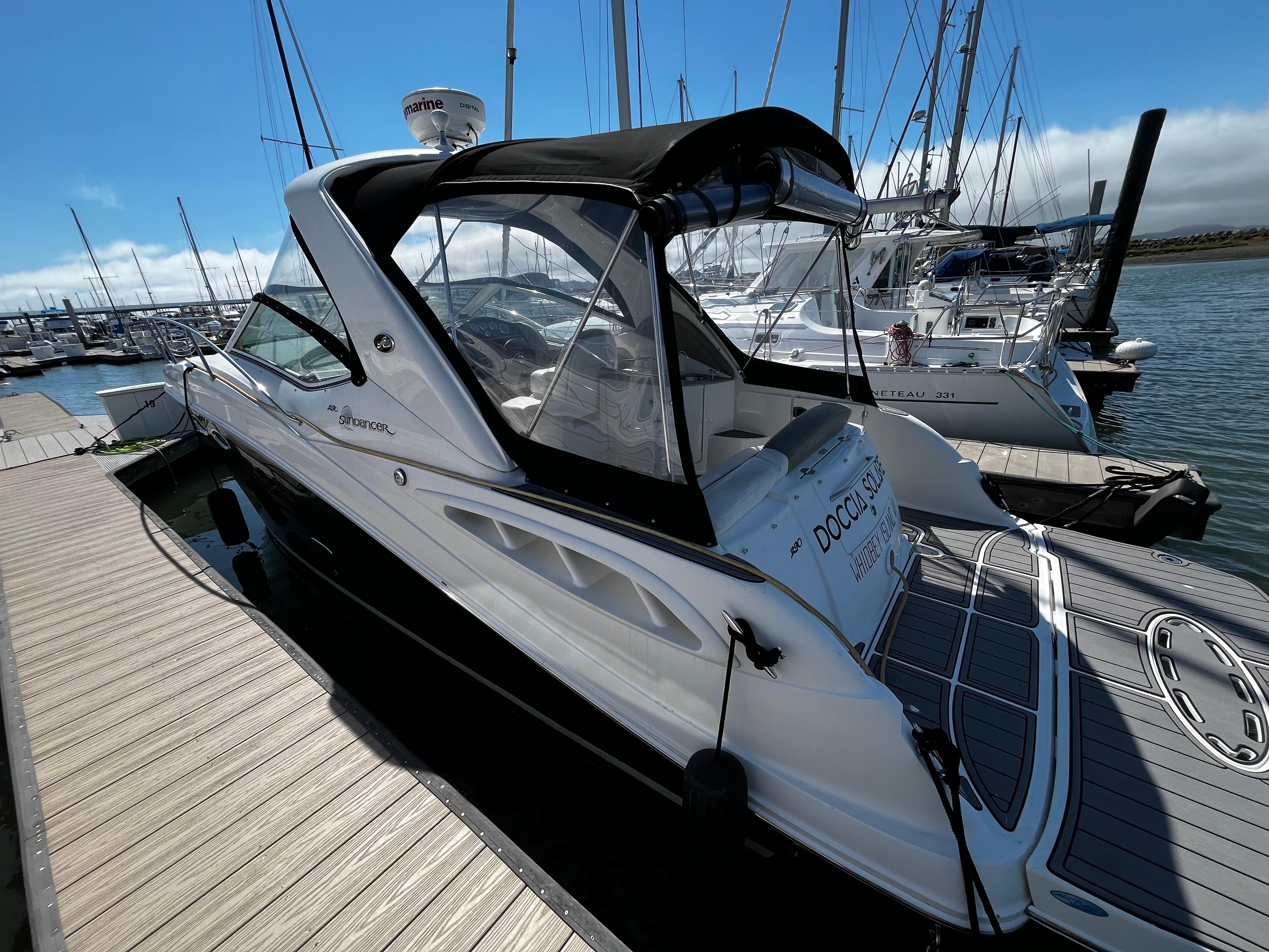 2006 Sea Ray 290 Sundancer docked at marina, featuring sleek design and spacious deck.