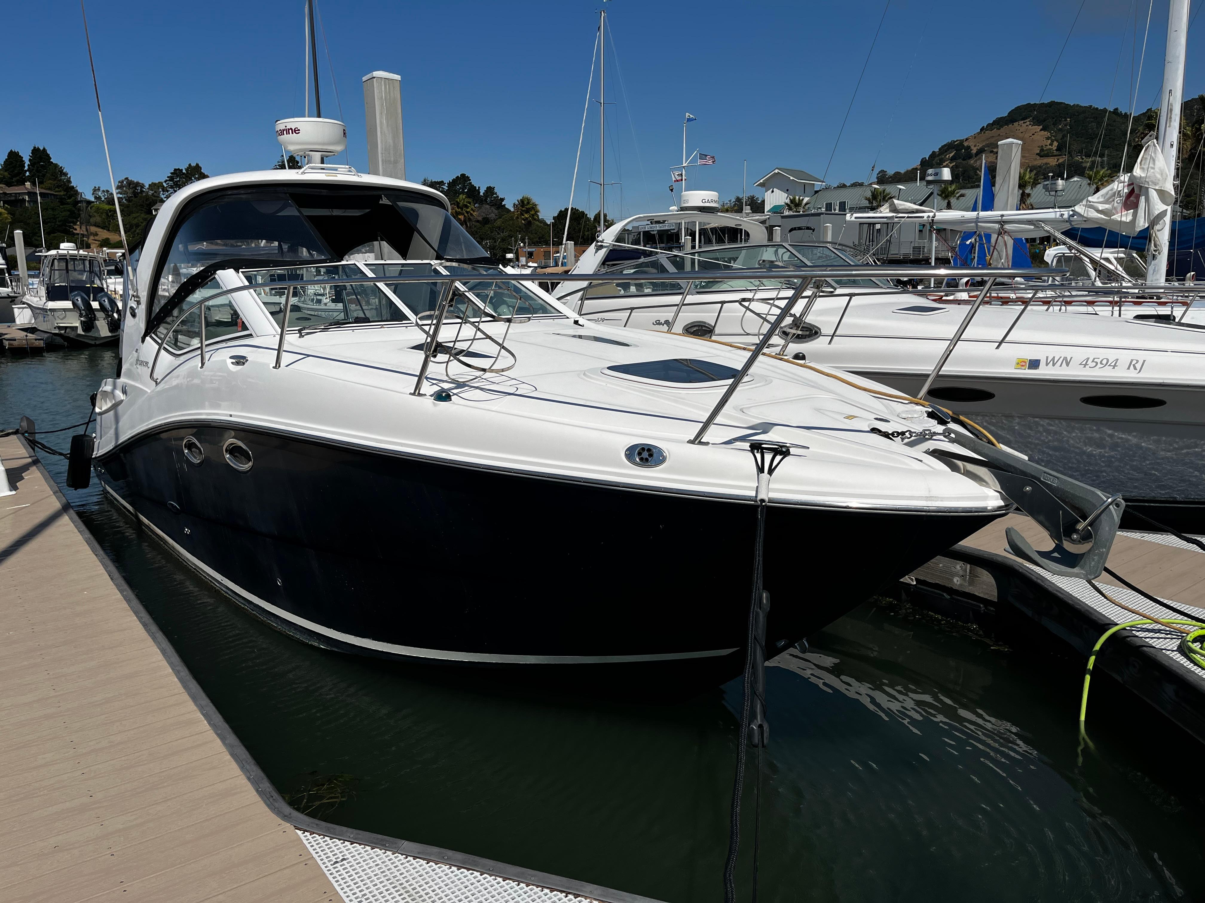 2006 Sea Ray 290 Sundancer docked at a marina under clear blue skies.