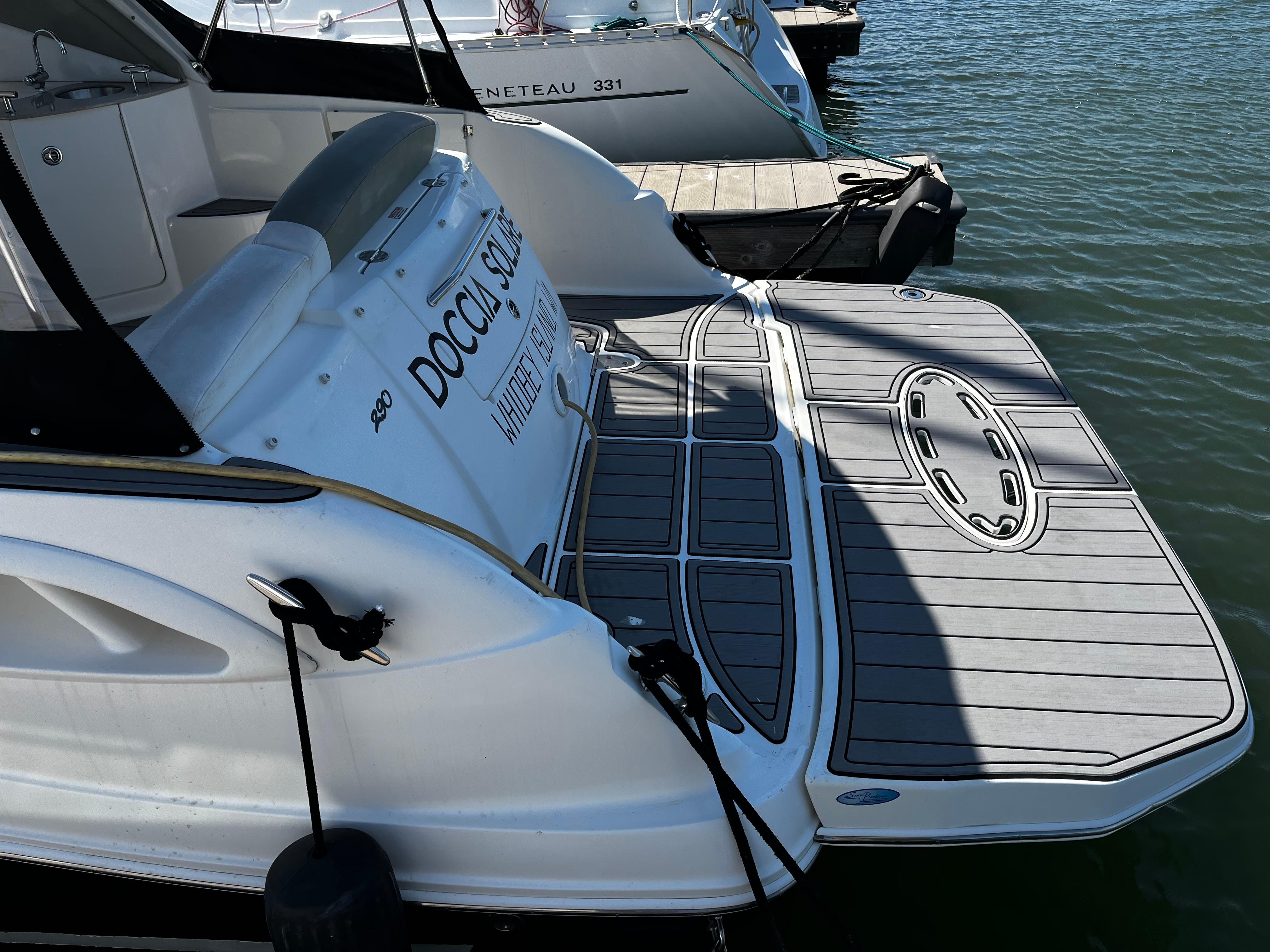 2006 Sea Ray 290 Sundancer docked, featuring a spacious swim platform and sleek design.