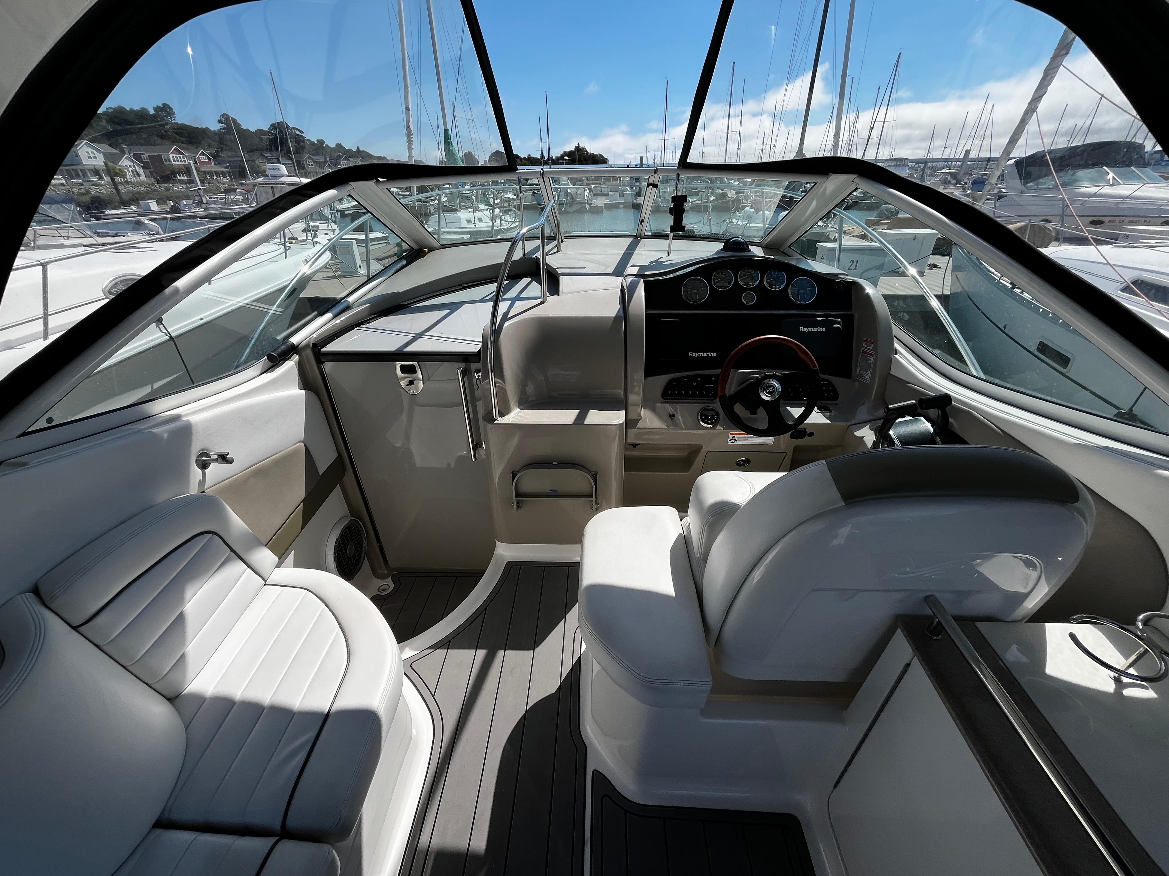 2006 Sea Ray 290 Sundancer cockpit with modern controls and seating, docked at marina.