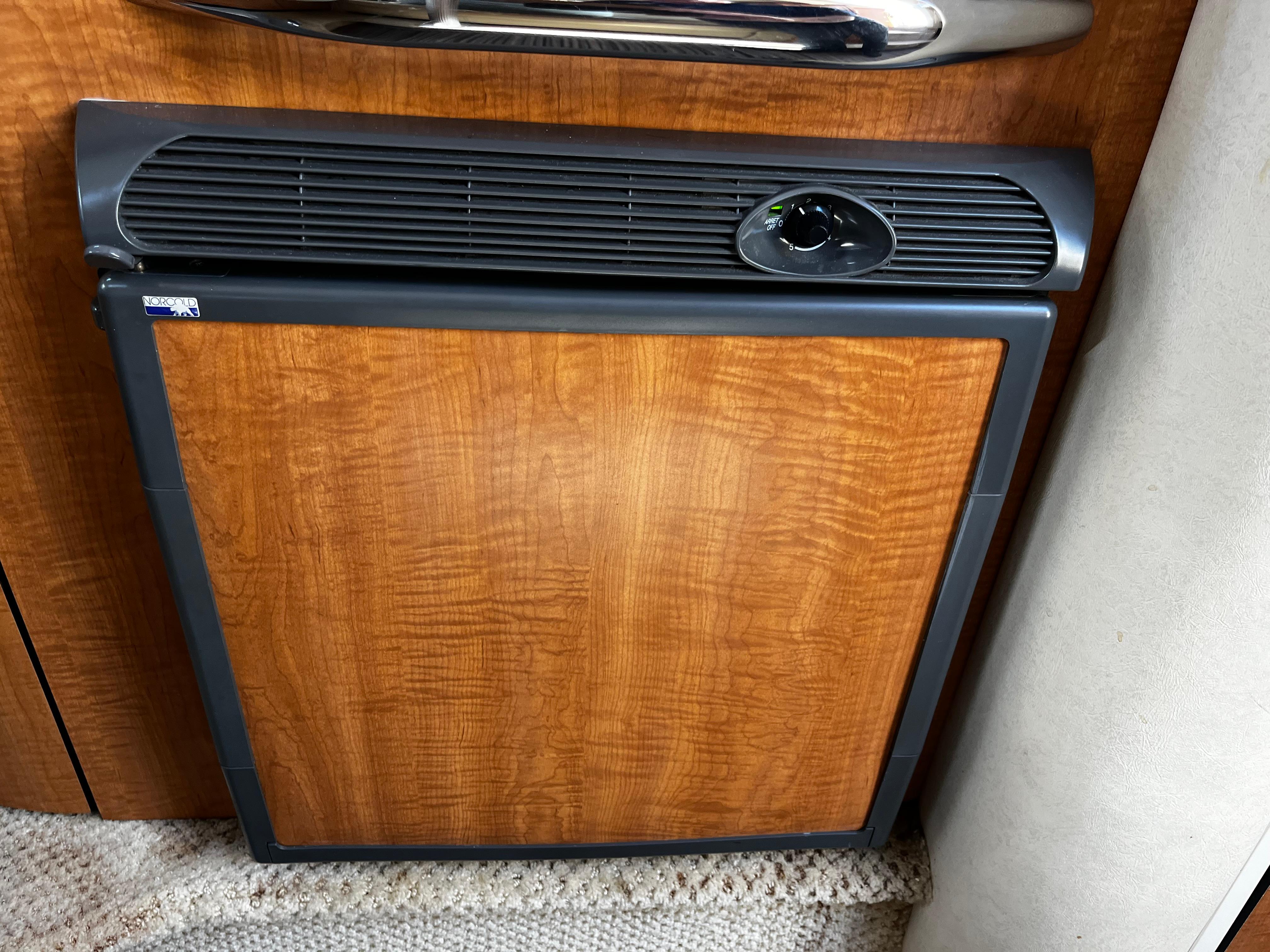 Wood-paneled refrigerator in 2006 Sea Ray 290 Sundancer boat interior.