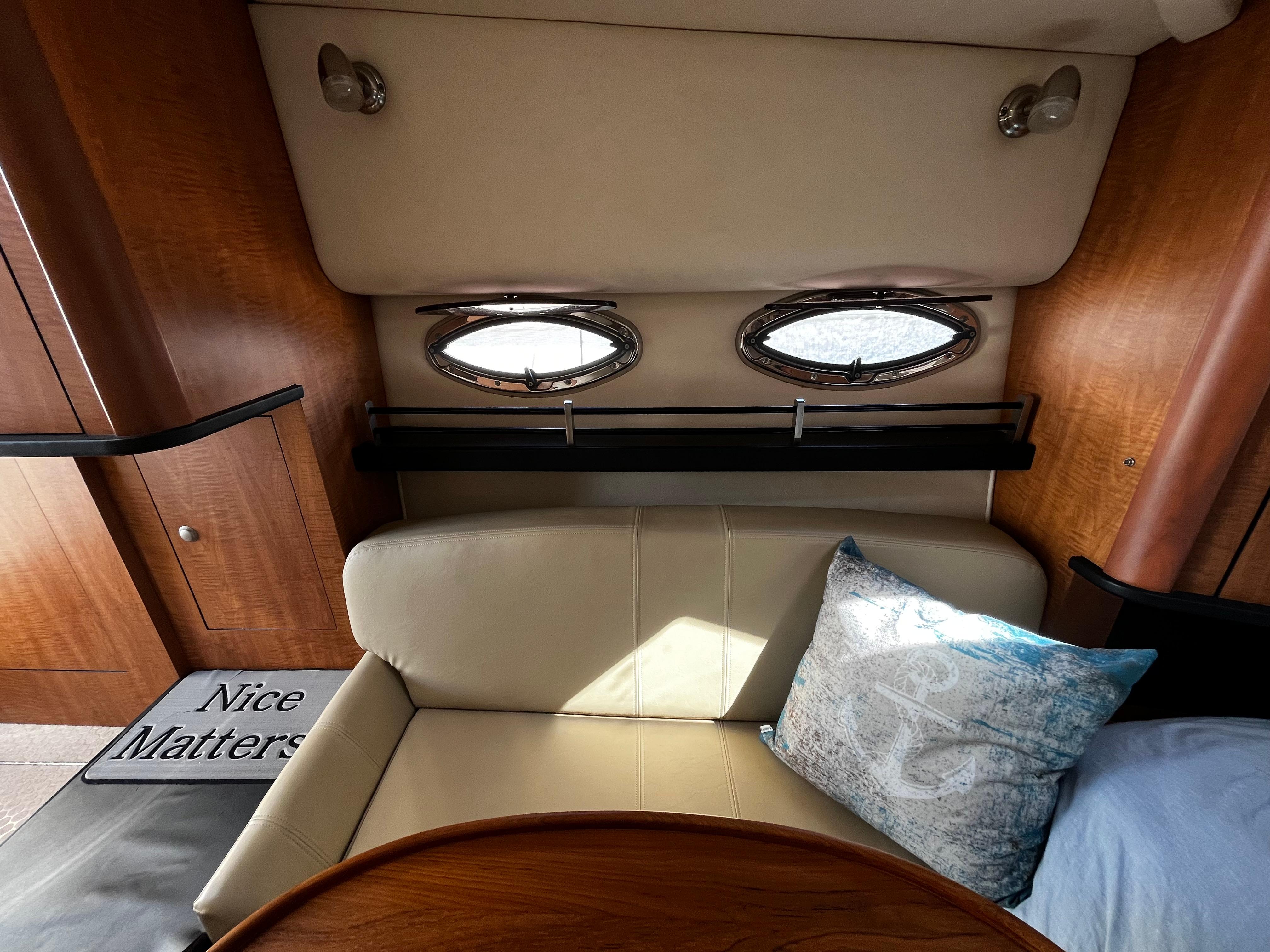 Interior of 2006 Sea Ray 290 Sundancer with beige seating and nautical-themed pillow.
