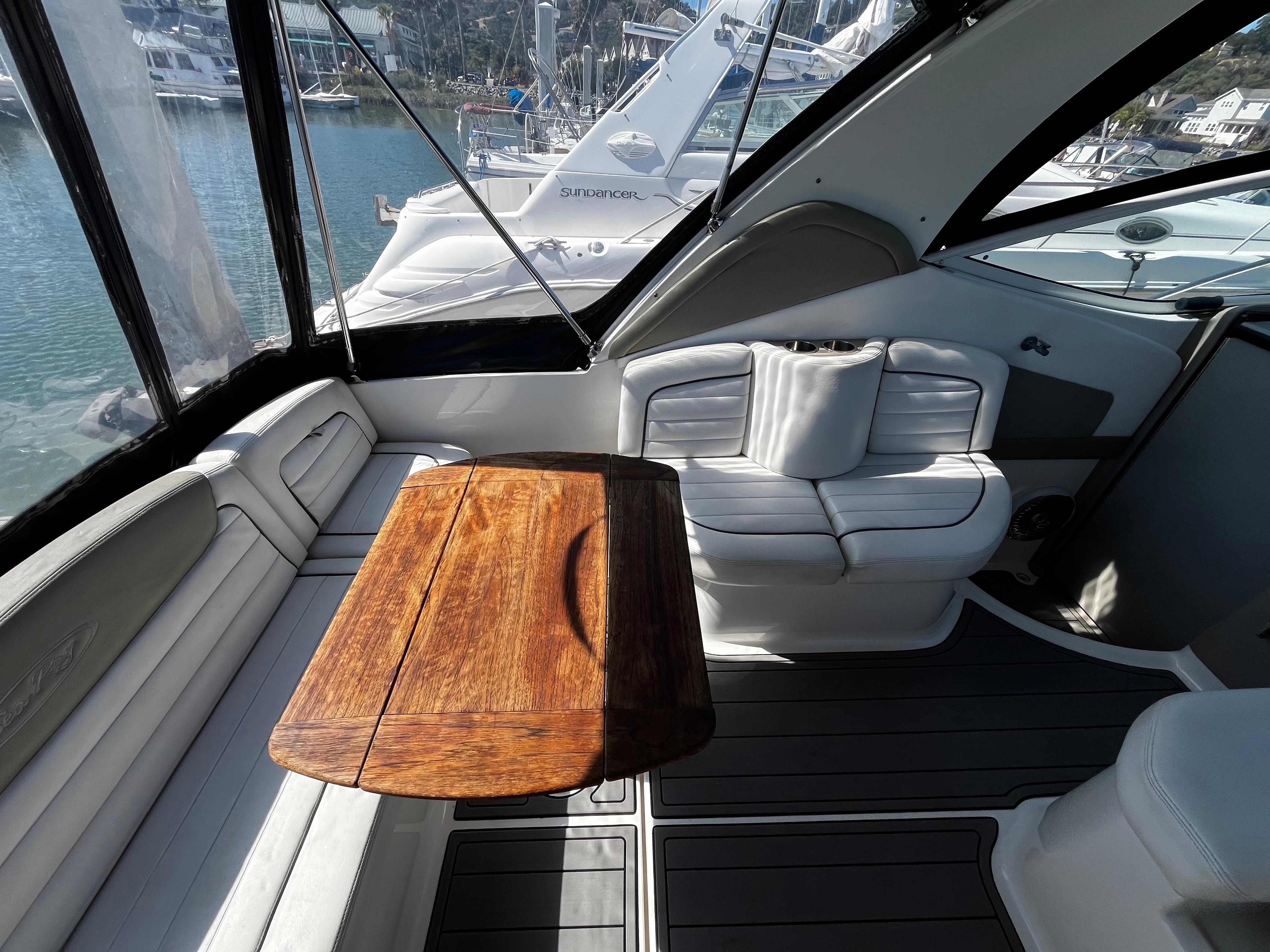 2006 Sea Ray 290 Sundancer interior with wooden table and white seating.