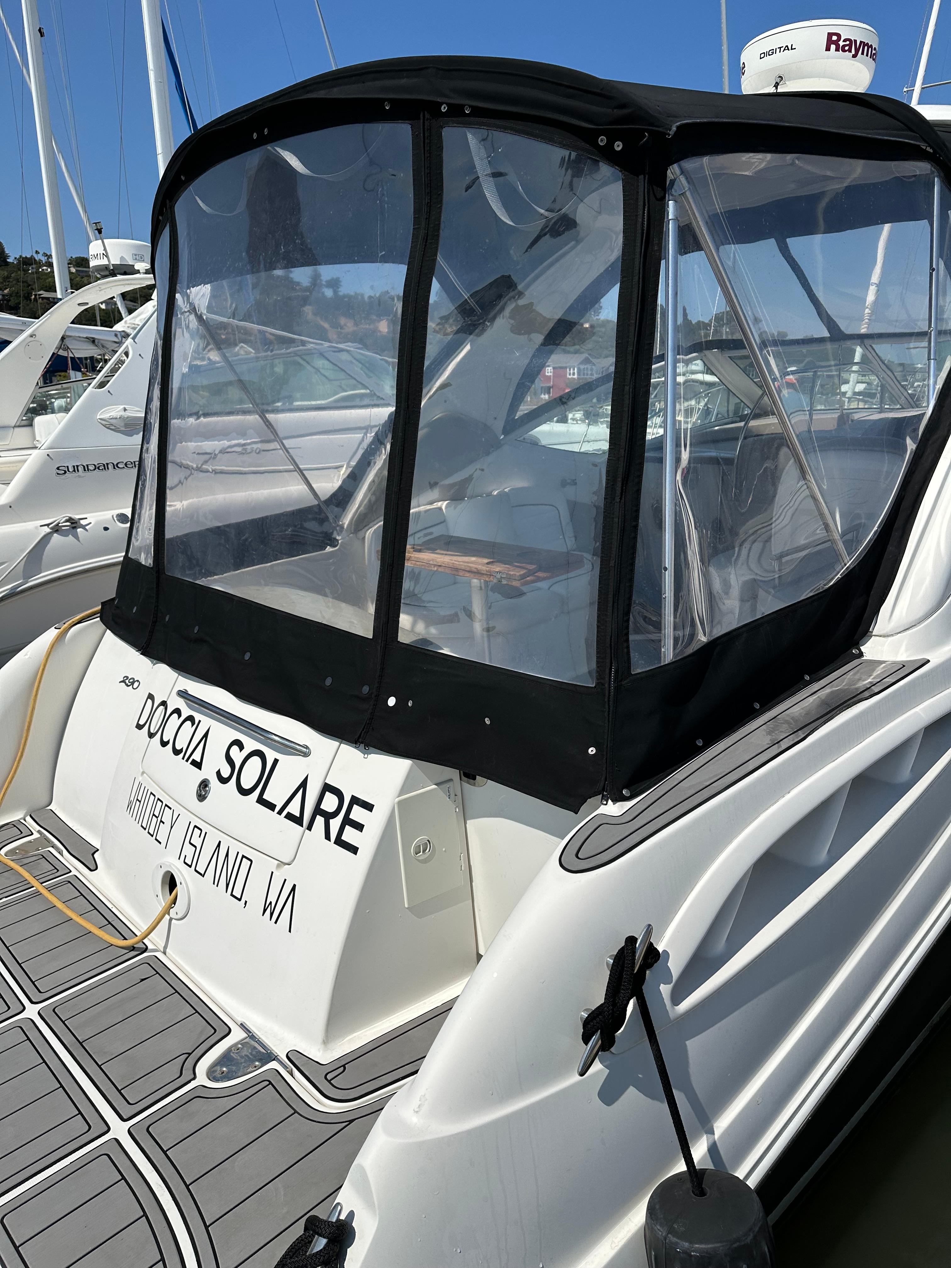 2006 Sea Ray 290 Sundancer docked, featuring a covered cockpit and visible boat name.