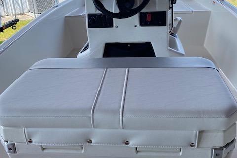 2026 Mako Pro Skiff 15 CC boat interior with steering console and cushioned seating.