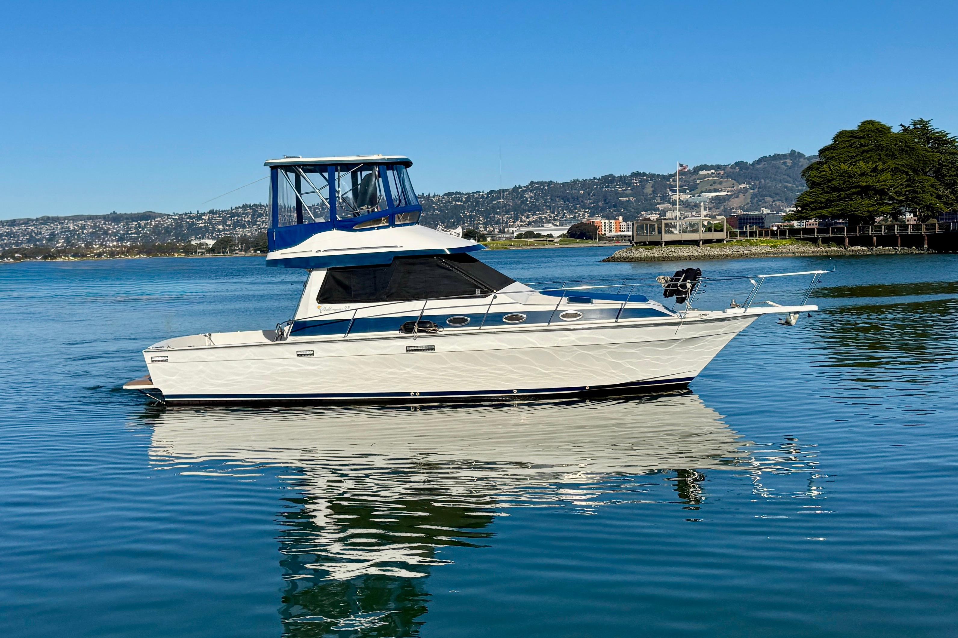1989 Mediterranean 38 yacht on calm water with scenic background.