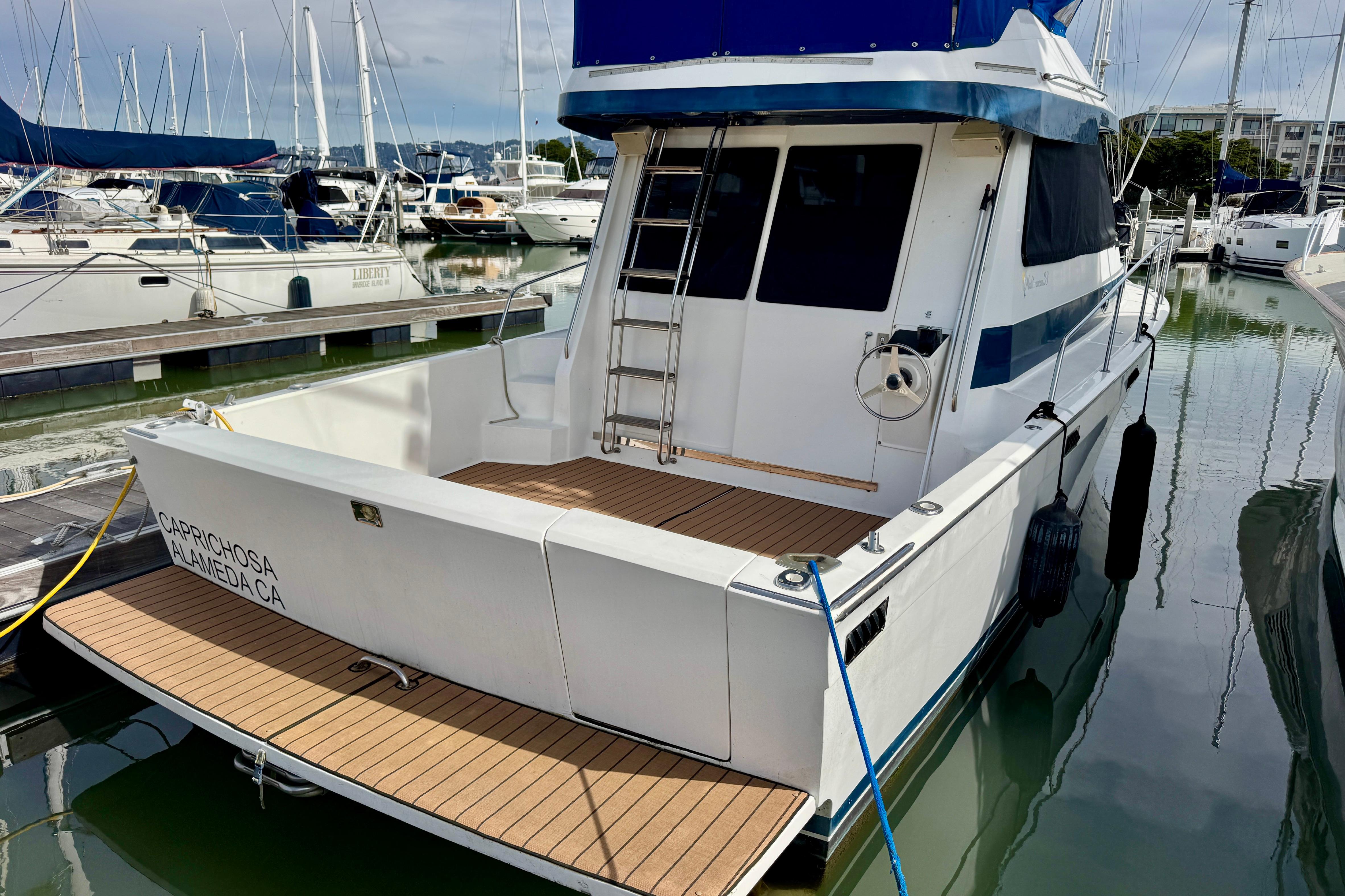 1989 Mediterranean 38 yacht docked in marina, featuring spacious deck and sleek design.